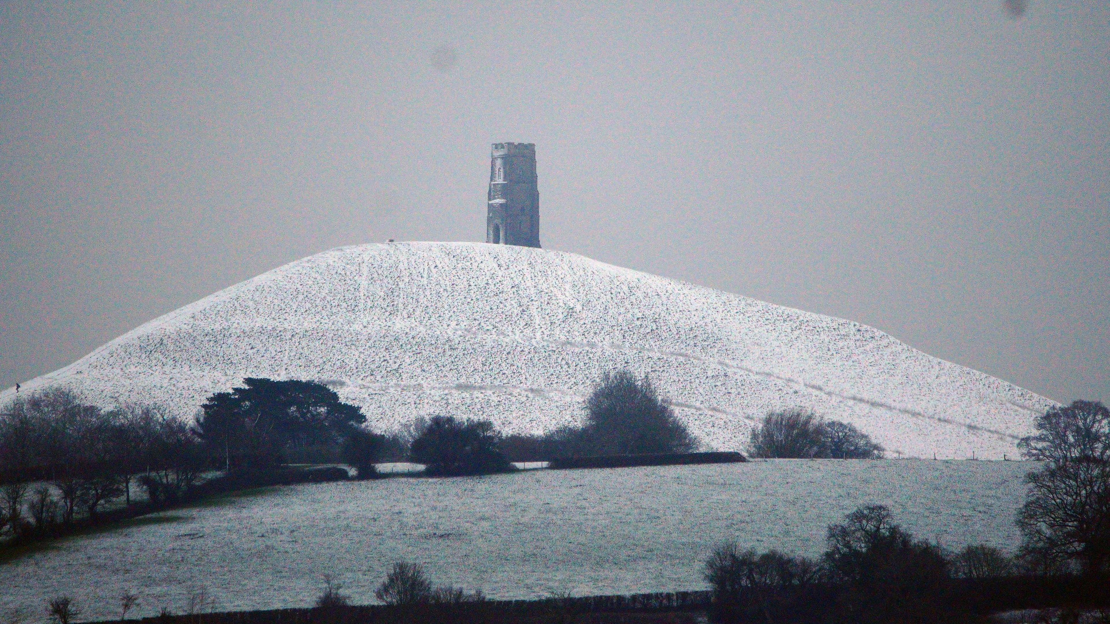 Light snow covers Glastonbury Tor, photo taken from an opposite hill