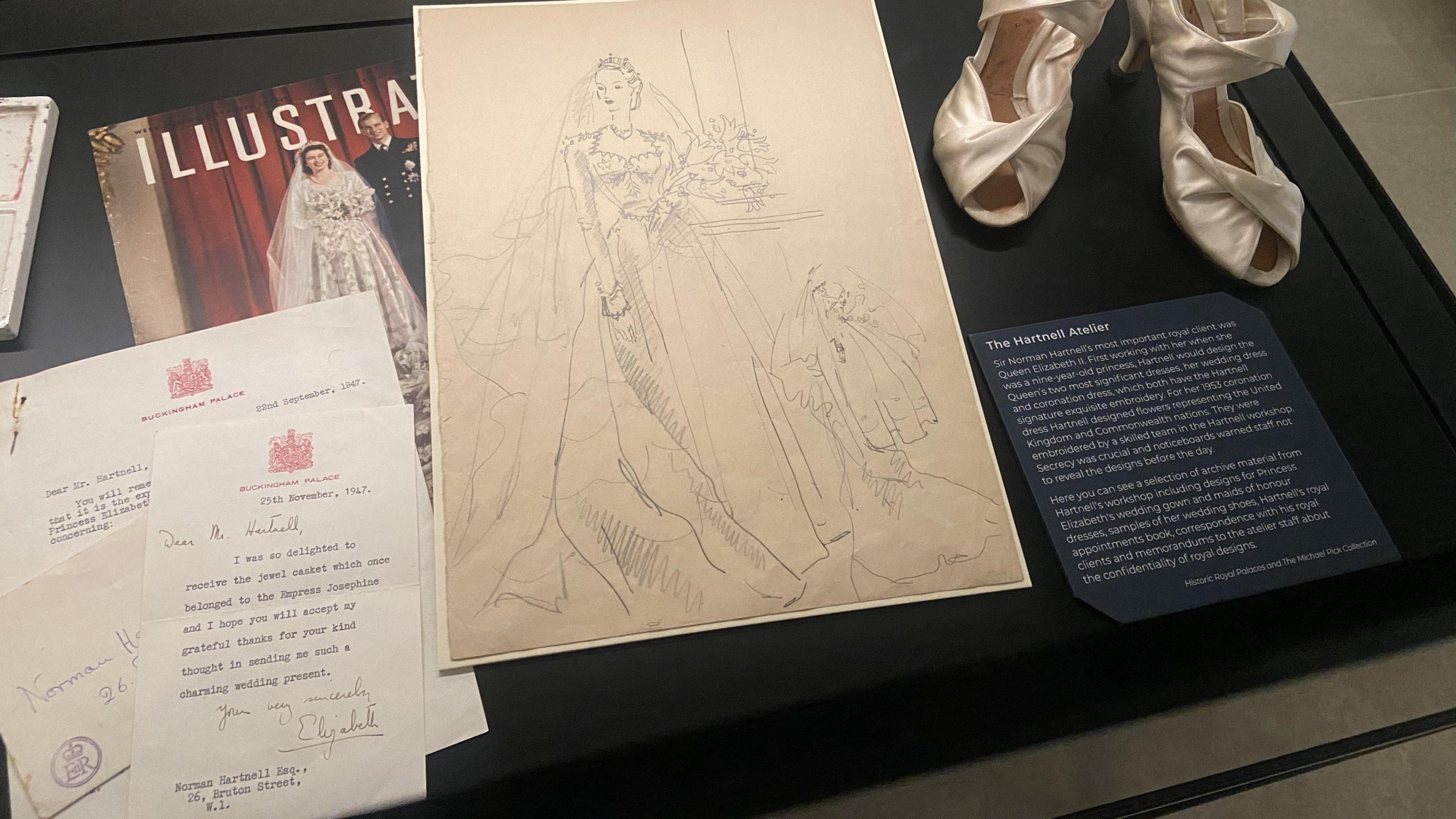 Correspondence between Queen Elizabeth II and Norman Hartnell alongside sketches for her wedding dress and an early mock-up of her wedding shoes. 