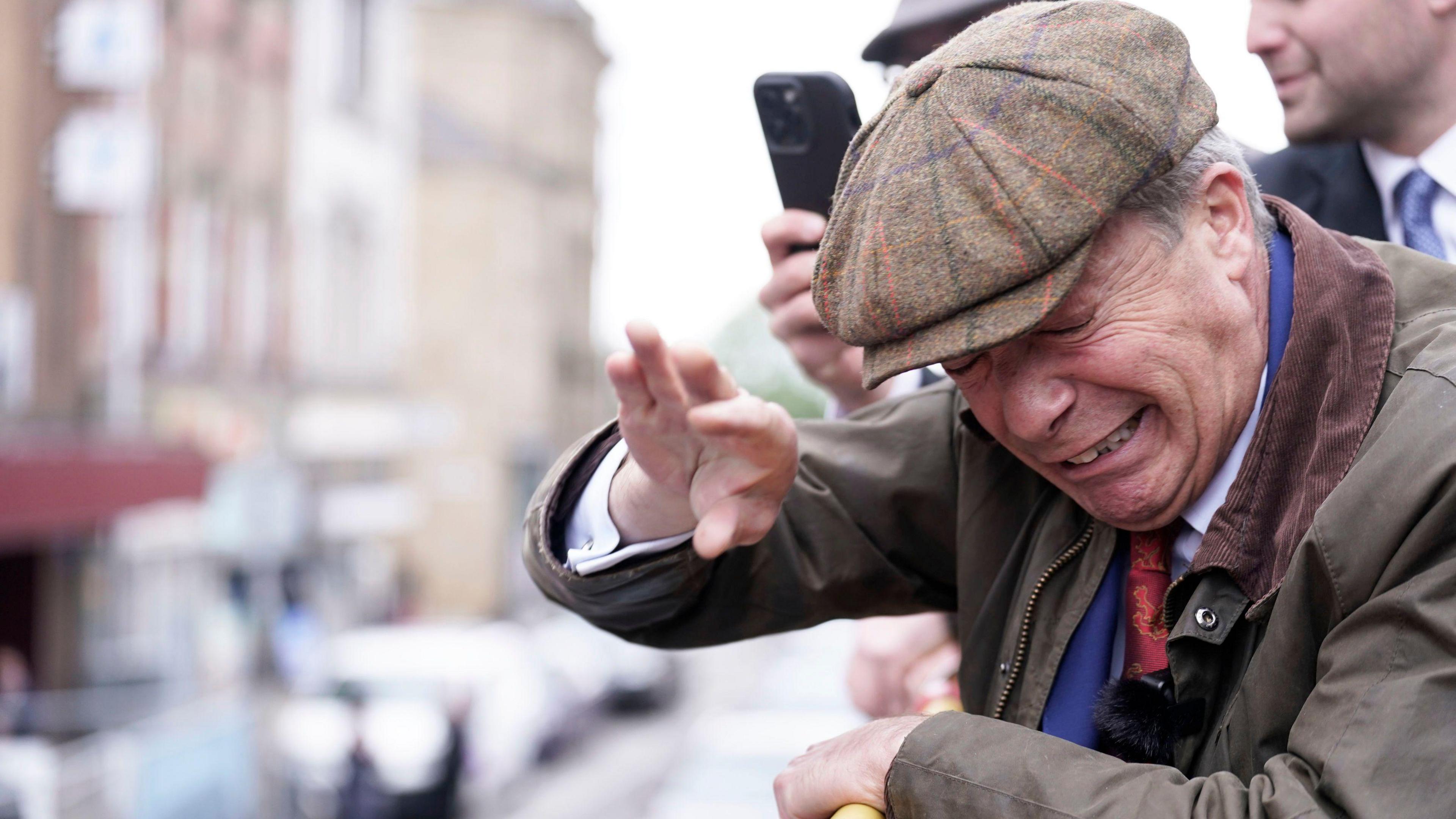 Nigel Farage flinches after an object is thrown at him.