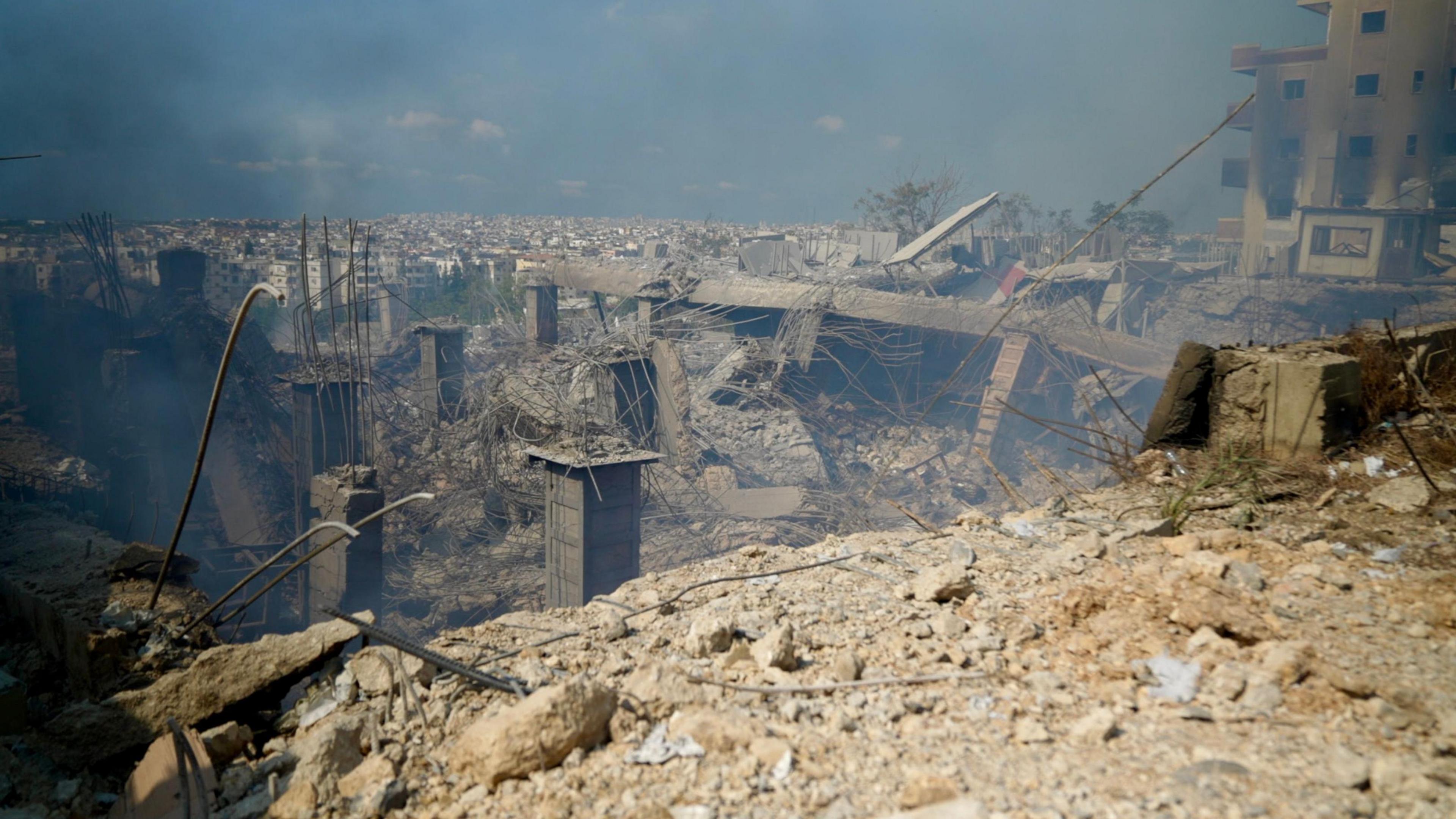 Smoke rises from the ruins of what appears to be a factory in Beirut, Lebanon