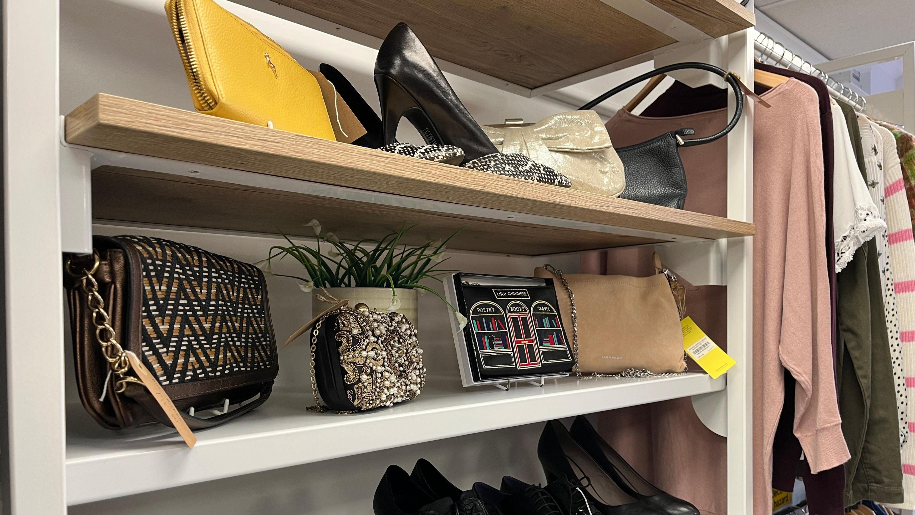 A shelving unit displaying designer shoes and handbags