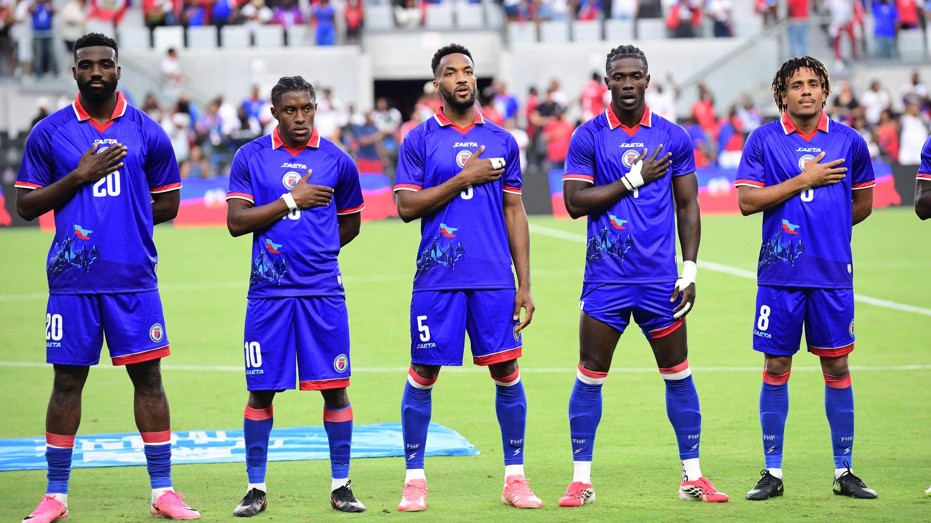 Haiti's players stand with right hands on their chests for the national anthem prior to kick off