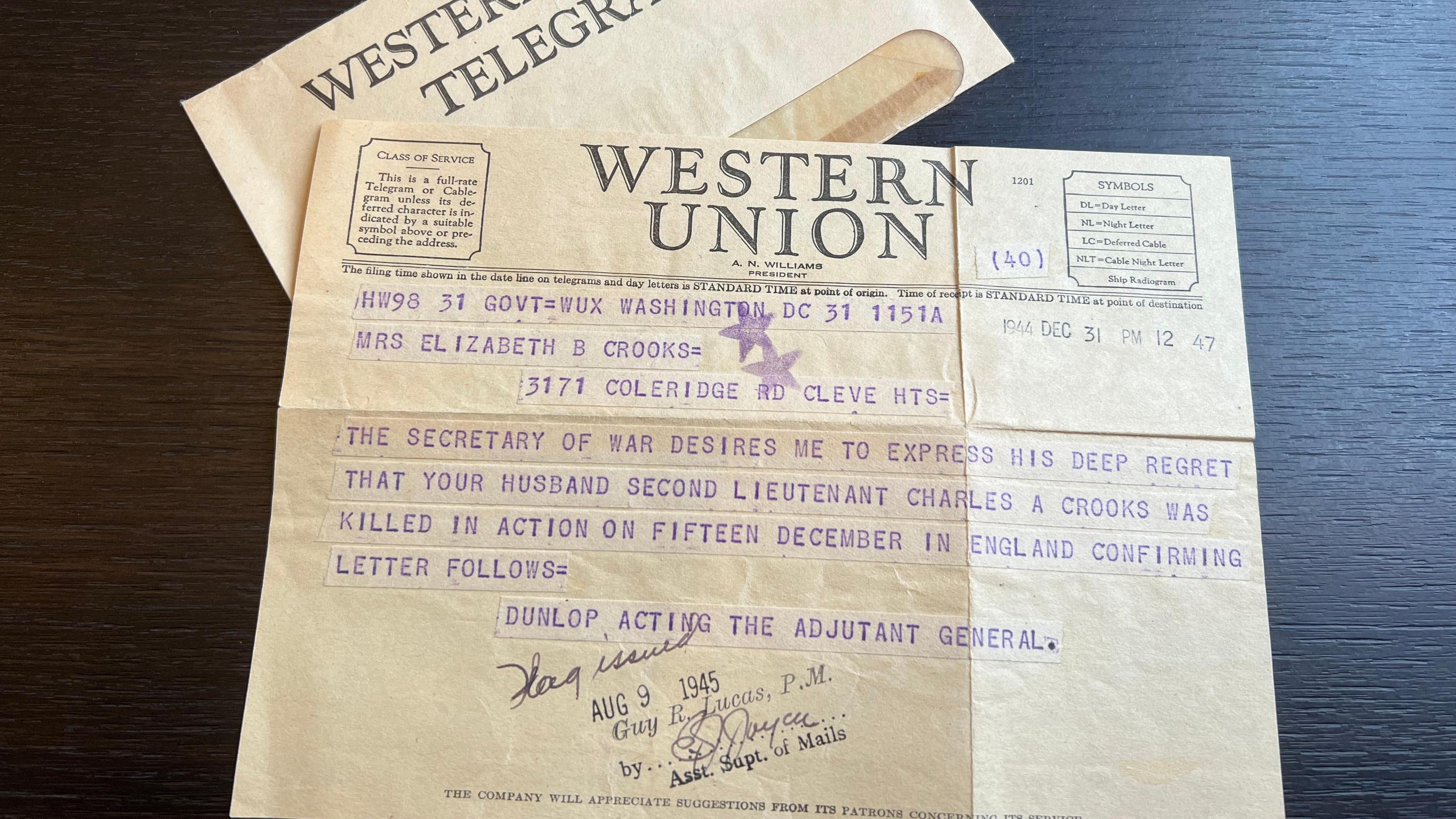 A telegram printed on yellowed paper, addressed to Mrs Elizabeth B Crooks, reading: The secretary of war desires me to express his deep regret that your husband Second Lieutenant Charles A Crooks was killed in action on fifteen December in England.