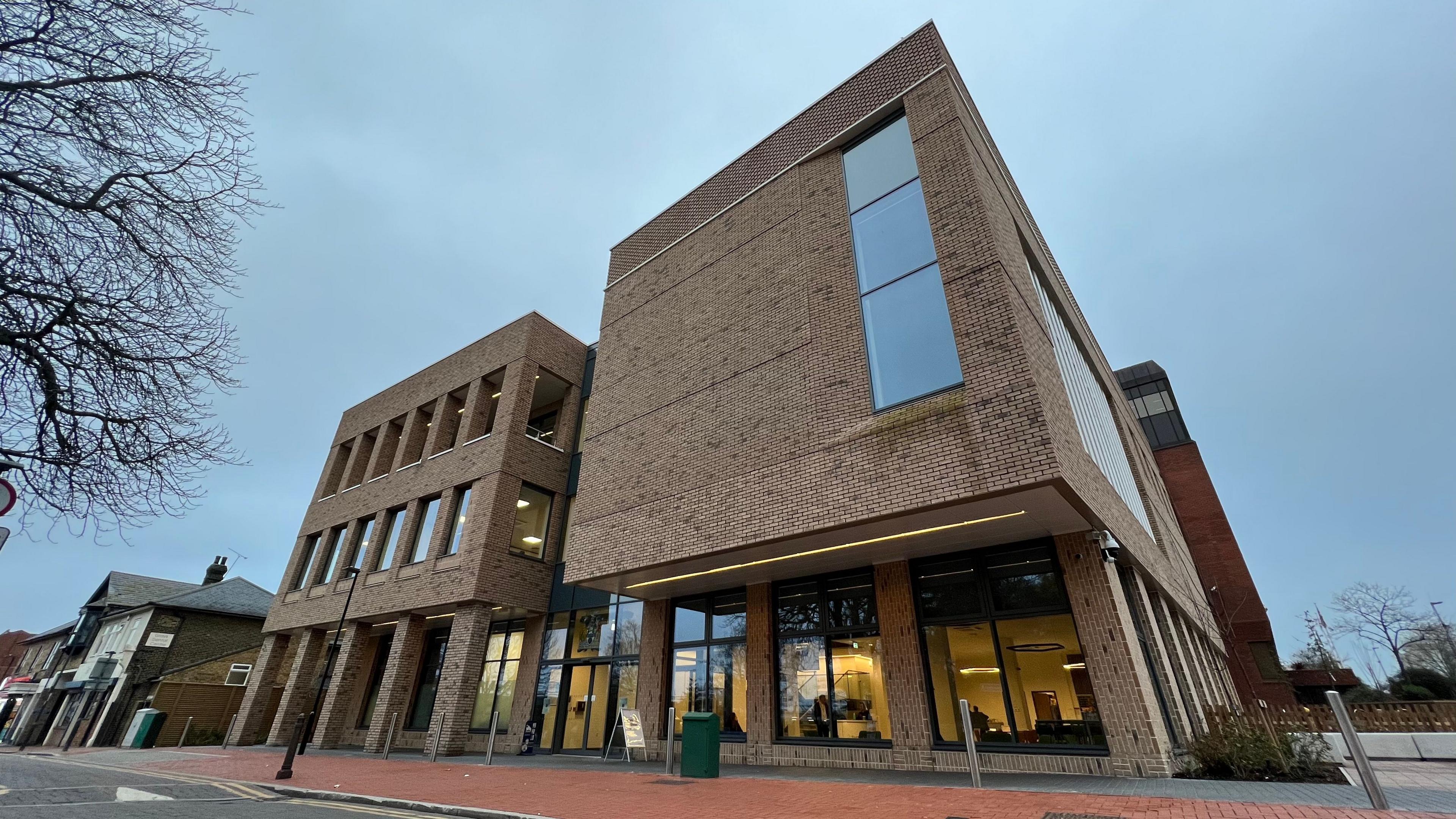A council building. It is a brown building with long tall windows