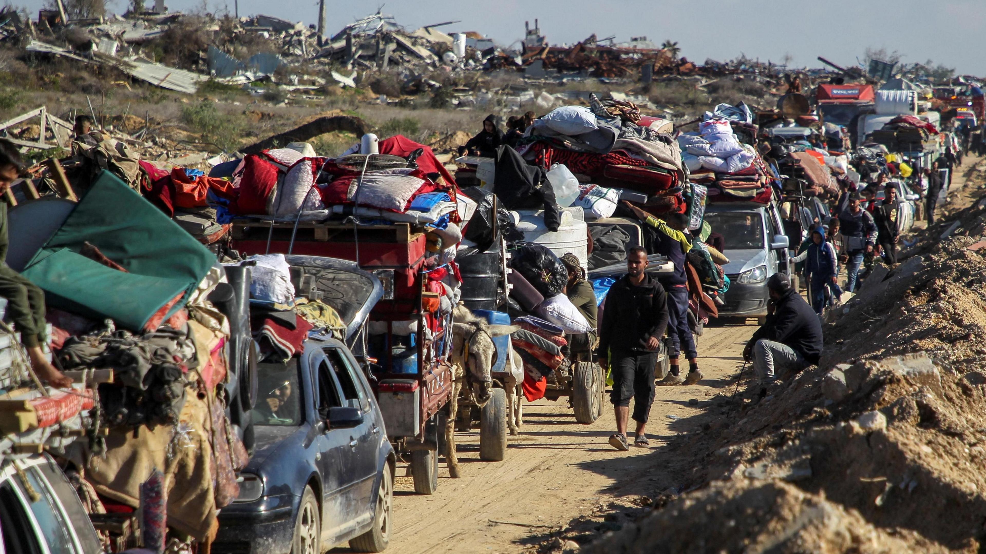 Displaced Palestinians queue to have their vehicles and donkey carts inspected at a checkpoint on the road to northern Gaza (27 January 2025)