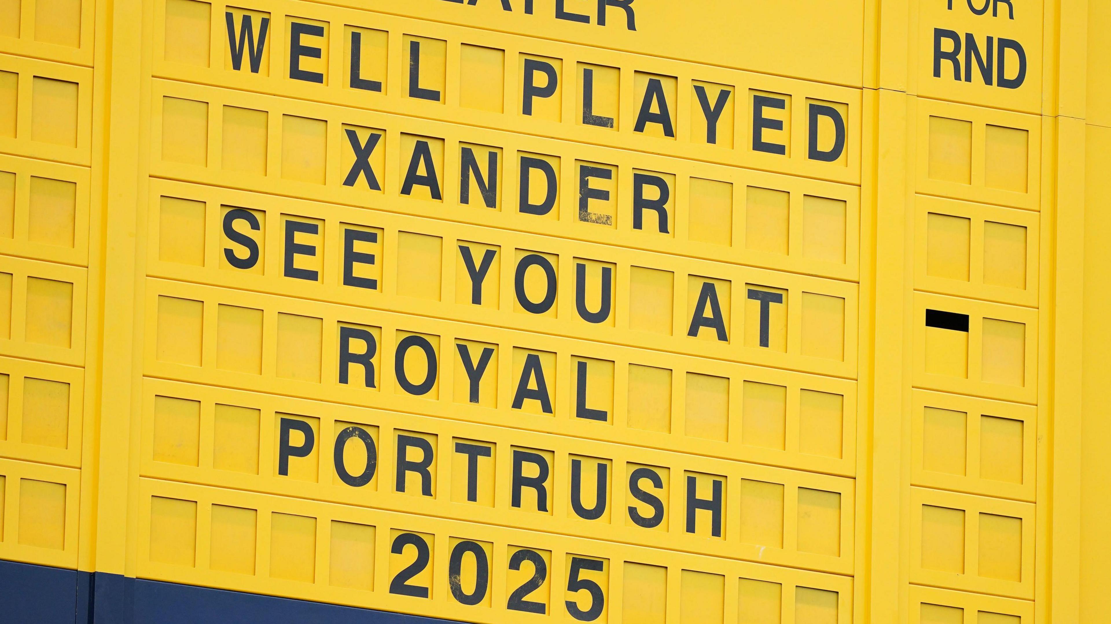 A general view of the yellow scoreboard at Royal Troon that says 'Well Played Xander, see you at Royal Portrush 2025'