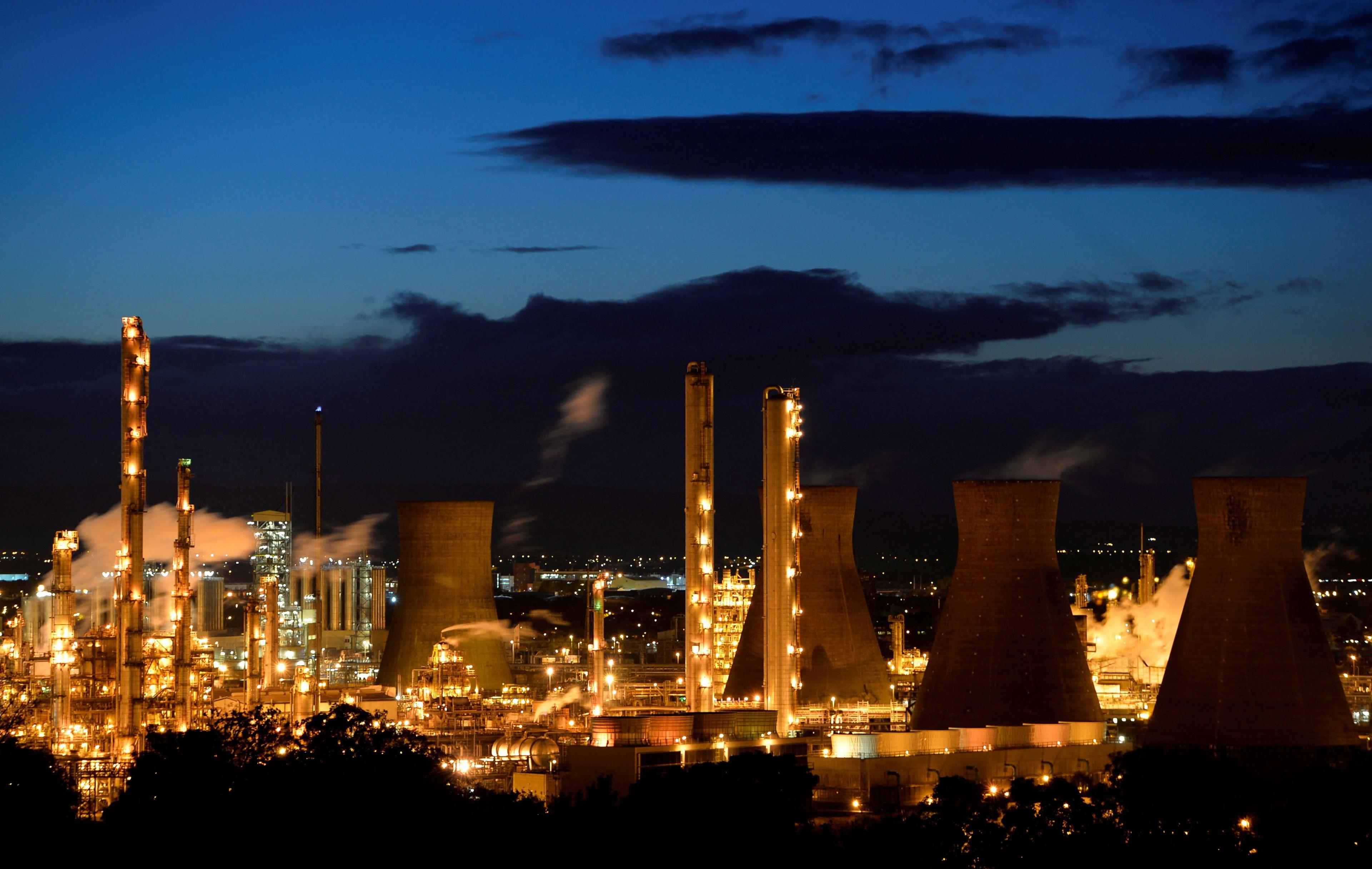 Grangemouth refinery at night. The sky is deep blue and the plant is lit a deep orange