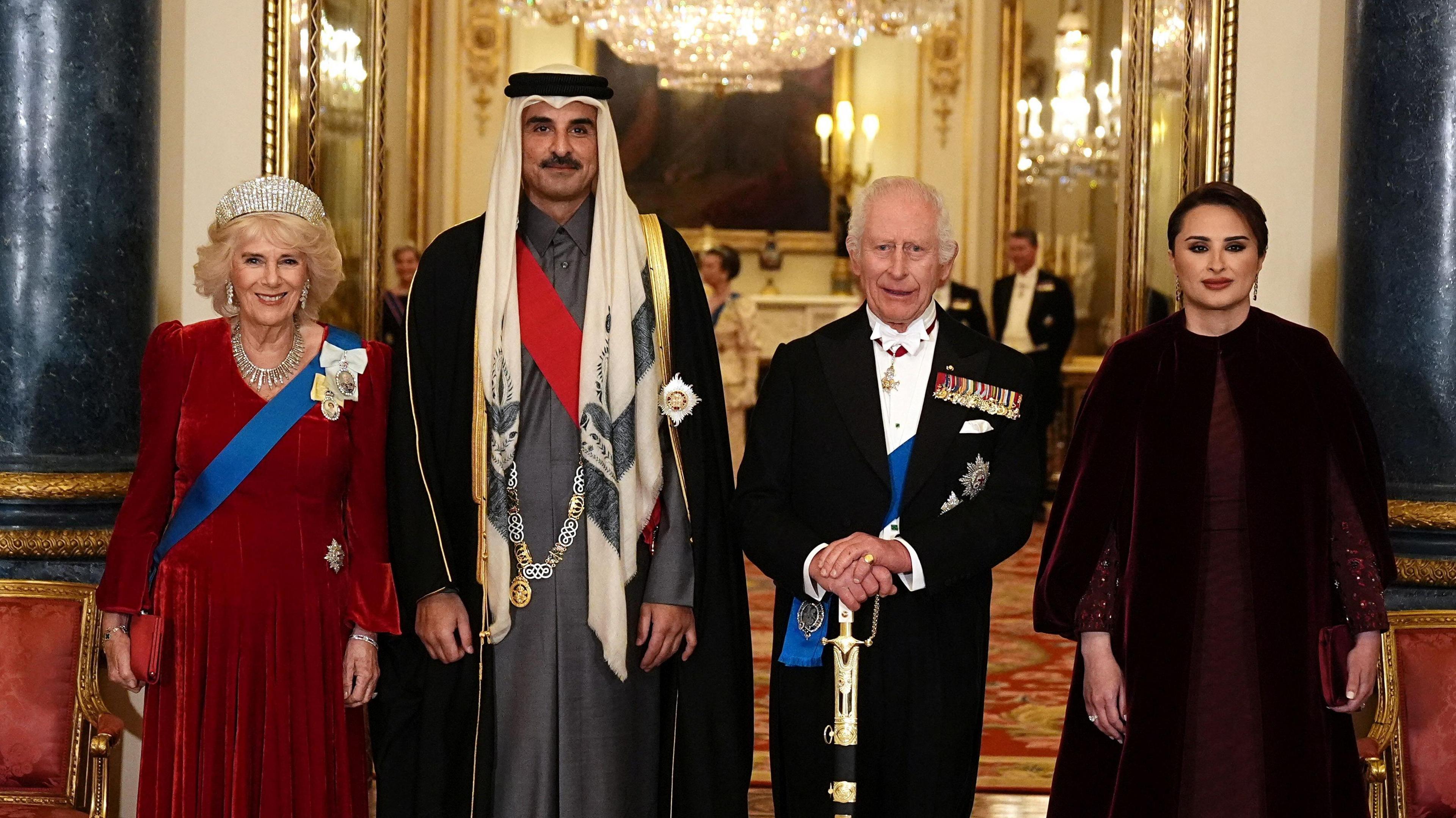 Queen Camilla, Qatari Emir Sheikh Tamim bin Hamad Al Thani, Queen Camilla, and the Qatari Emir's wife Sheikha Jawaher bint Hamad bin Suhaim Al Thani standing in fomral evening wear ahead of the state banquet, in Buckingham Palace