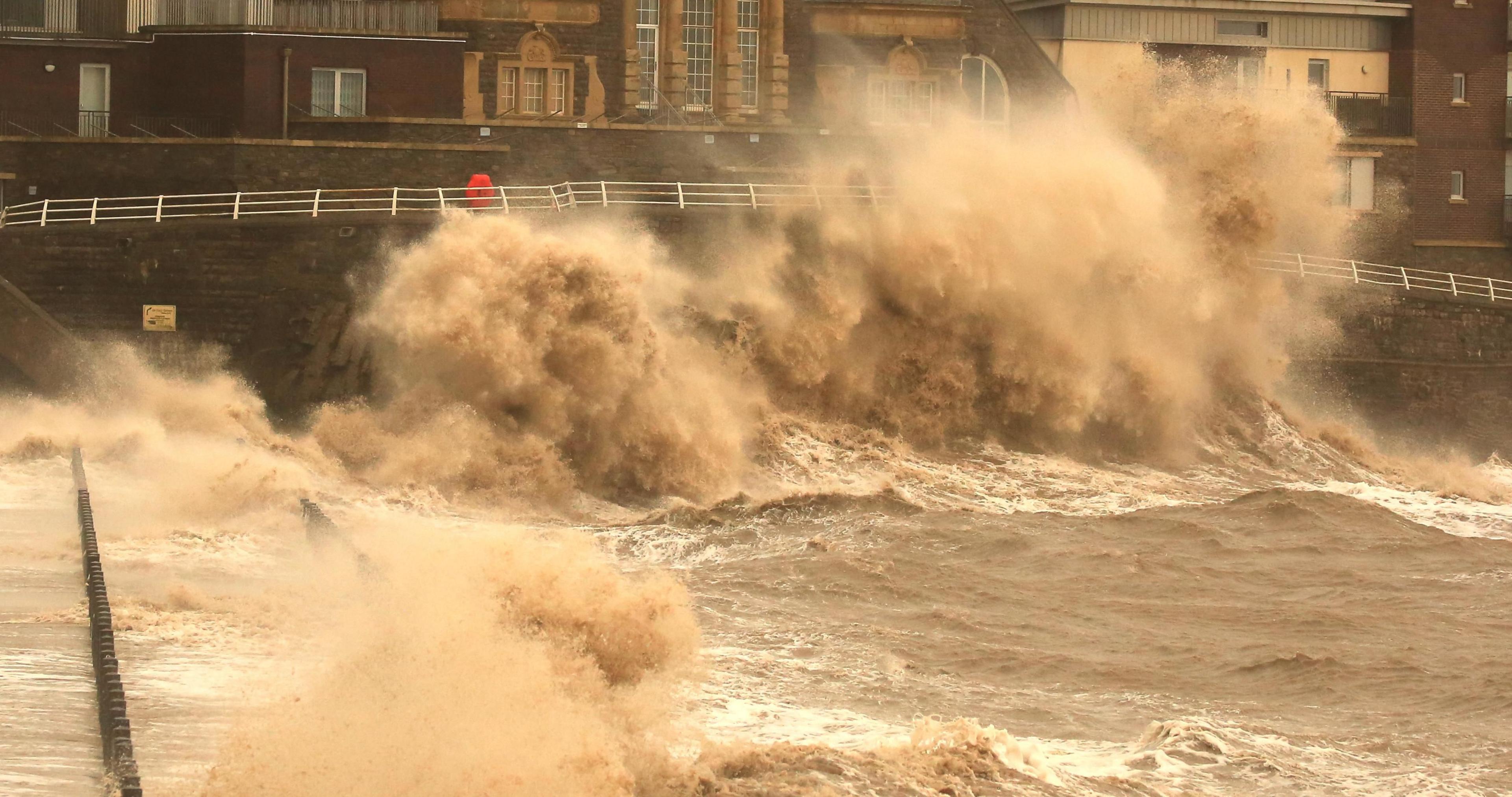 Large waves crash into marine walkway