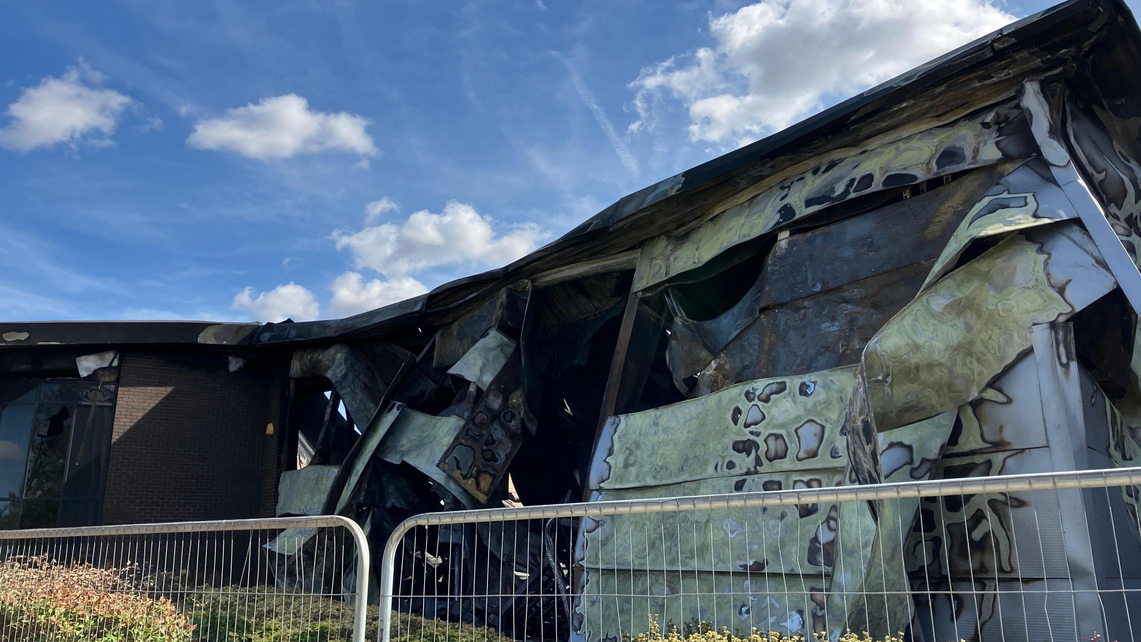 The outside of a building which is discoloured, smouldered and bent out of shape