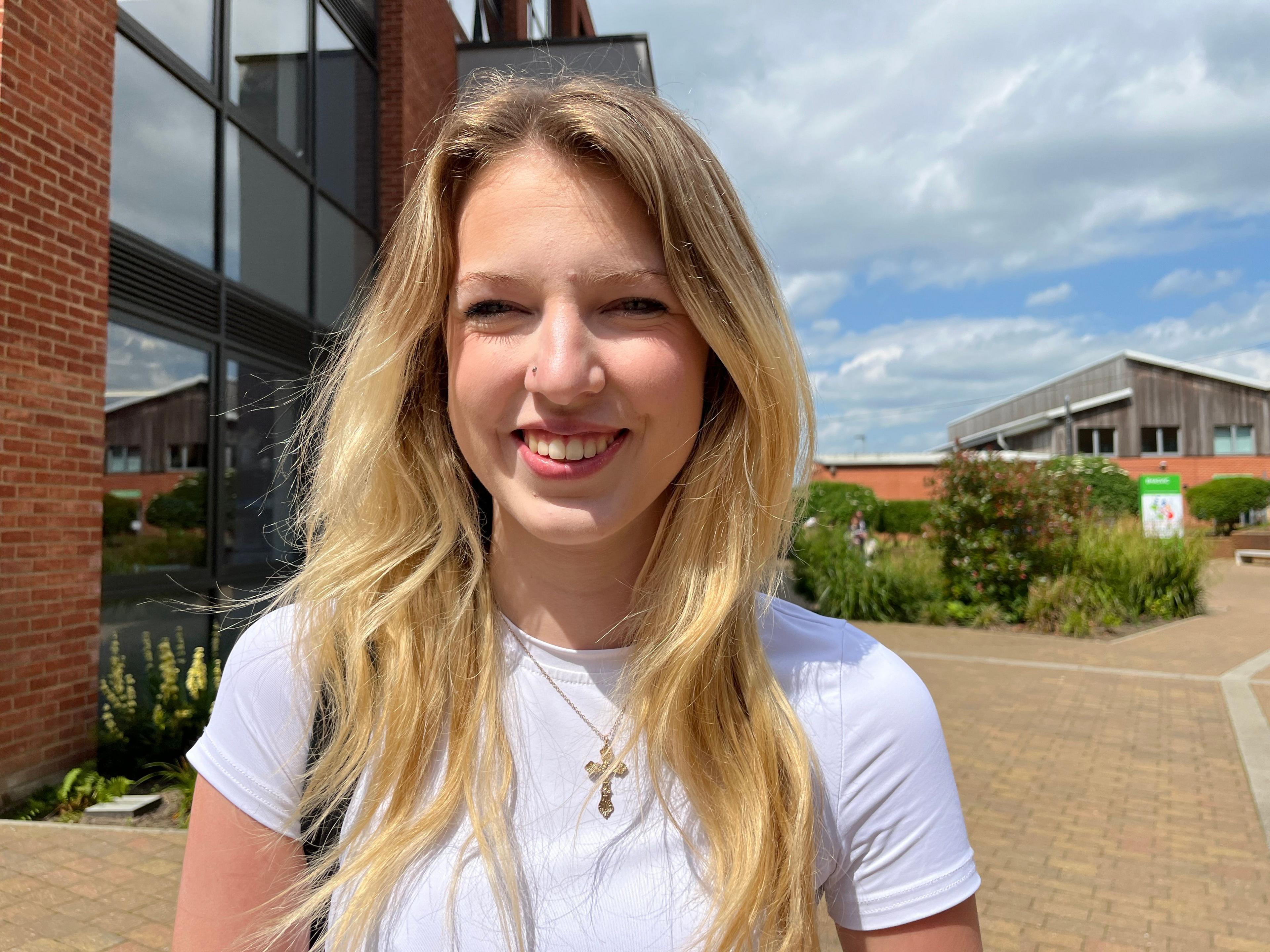 Mille is 18. She's smiling with long blonde hair and wears white t-shirt