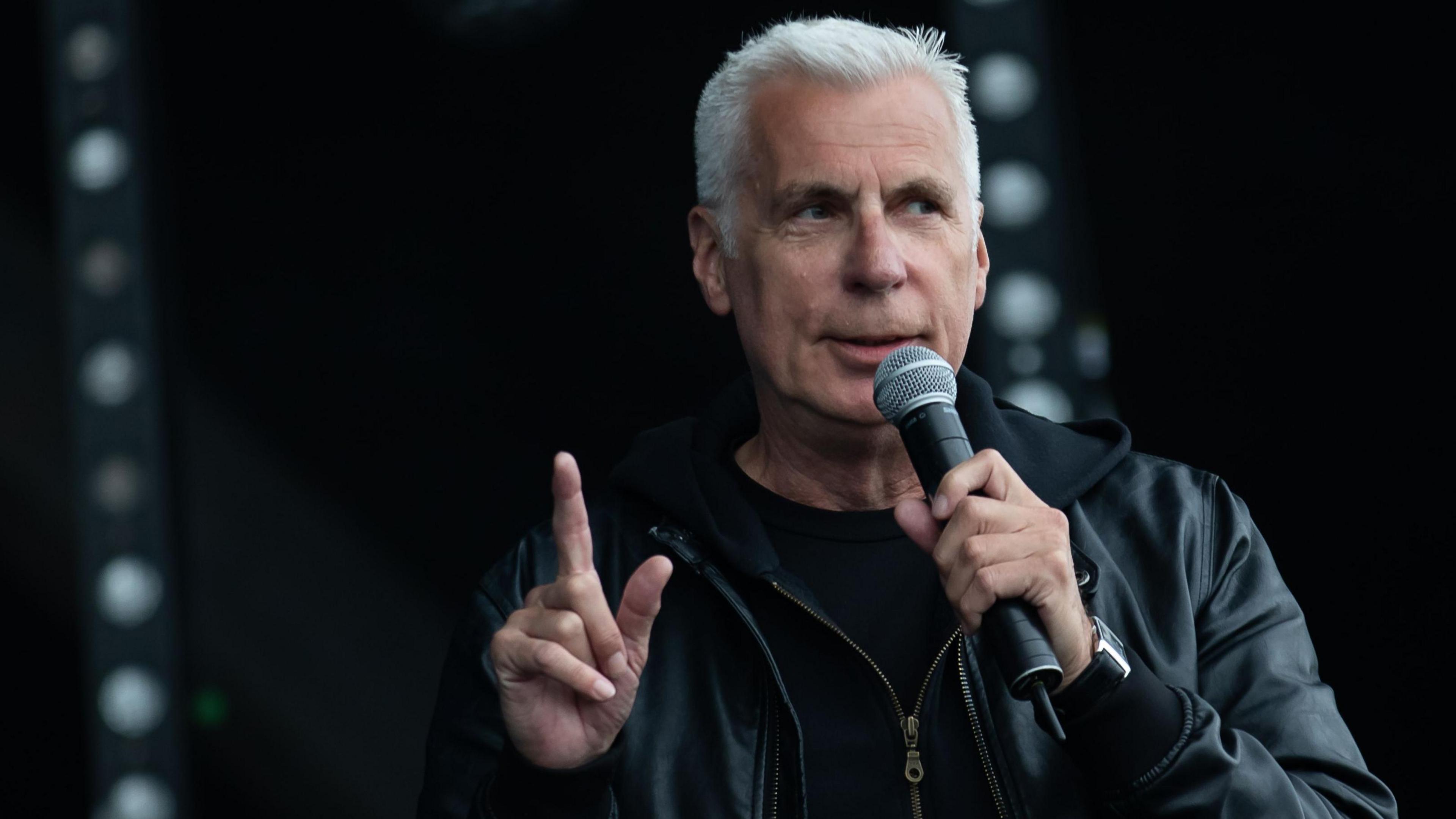 John Giddings speaking into a microphone.