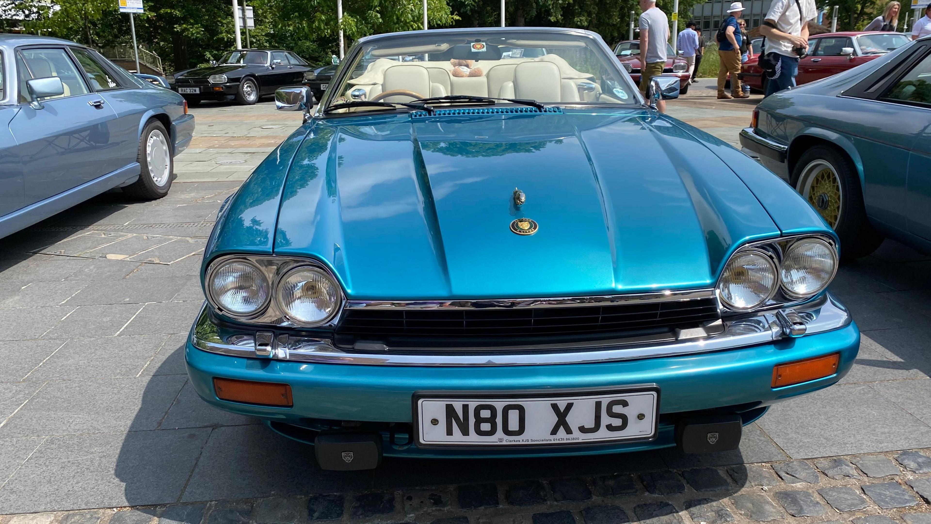 A turquoise car with thhe numberplate N80 XJS