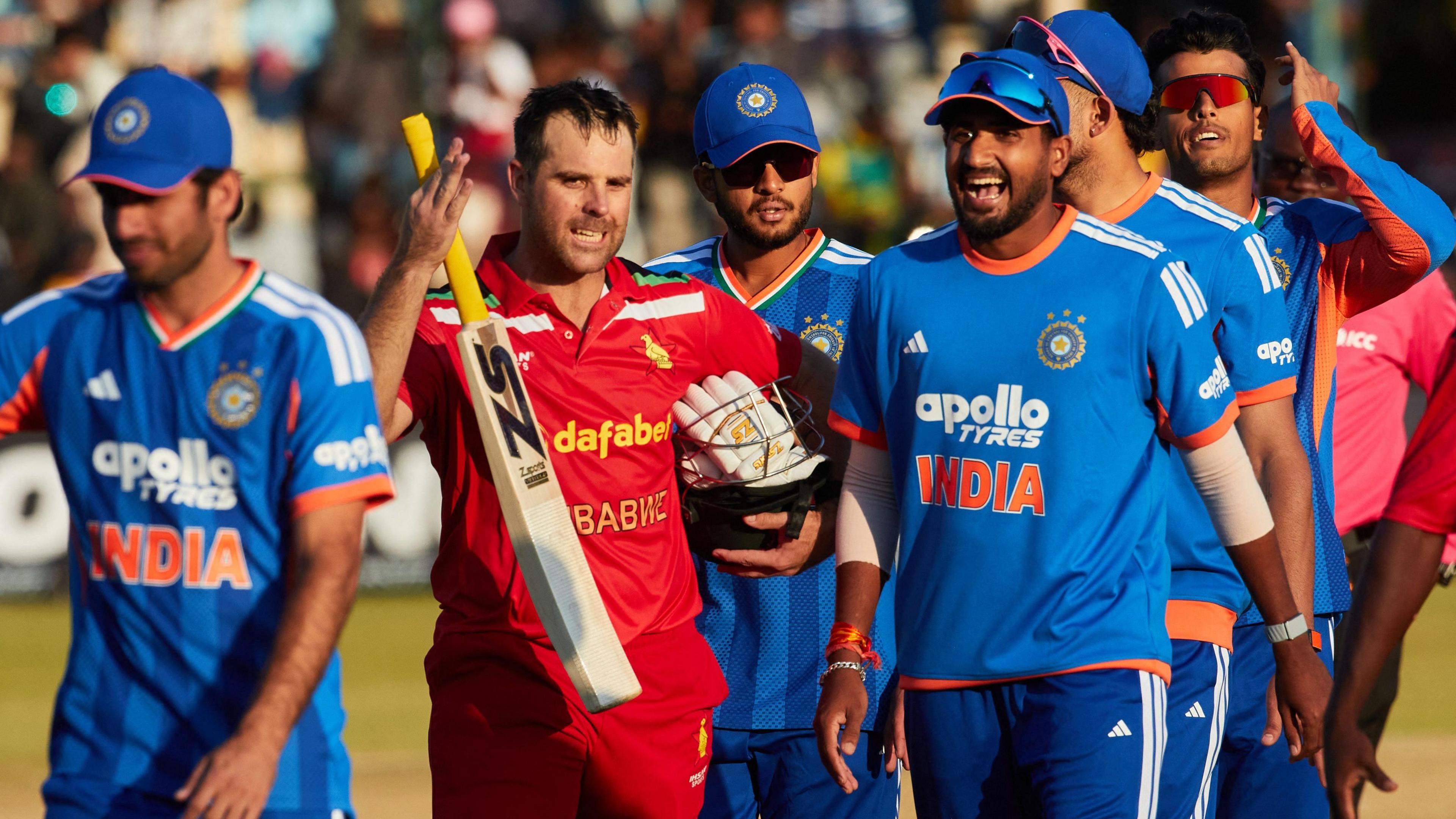 Zimbabwe batter Ryan Burl (centre) speaks with India players after India win the third Twenty20 international in Harare