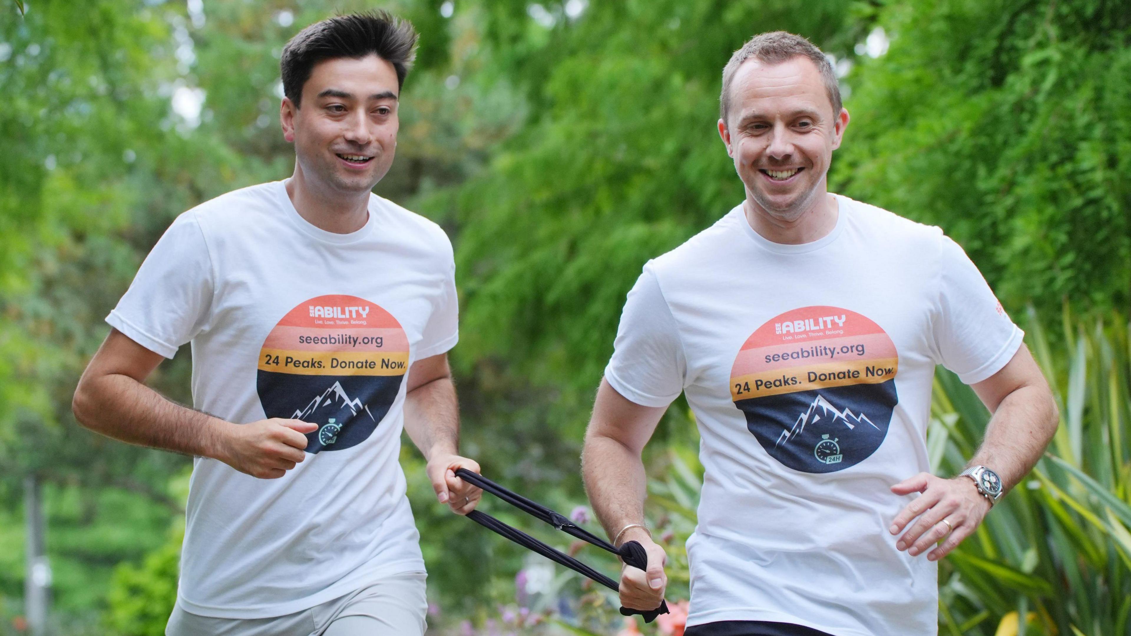 Michael Smith (left) and Jack Stacey running, both holding a band to keep them in tandem