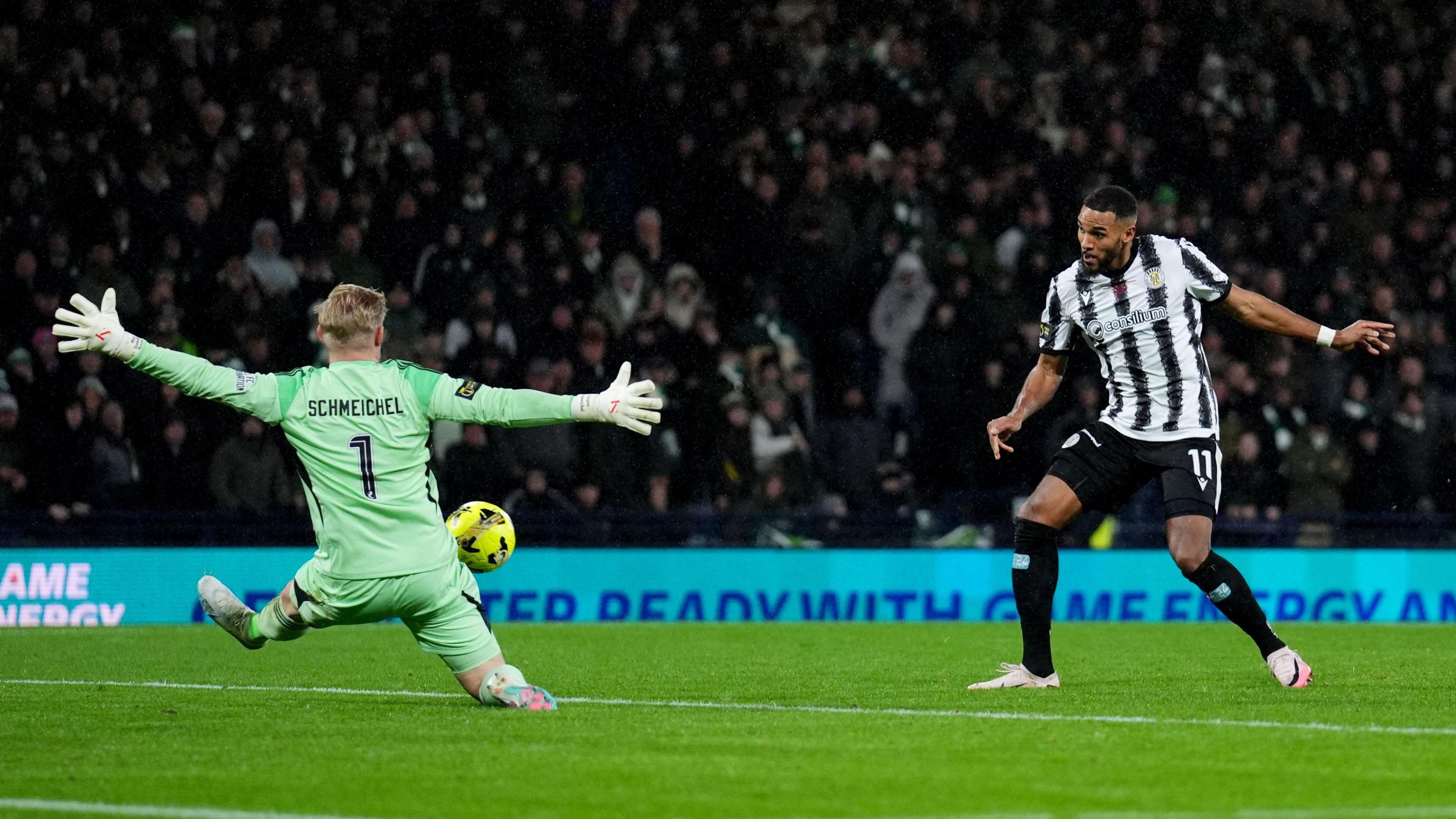St Mirren footballer Jonah Ayunga kicks the ball past Celtic goalkeeper Kasper Schmeichel, who reaches to try and save it
