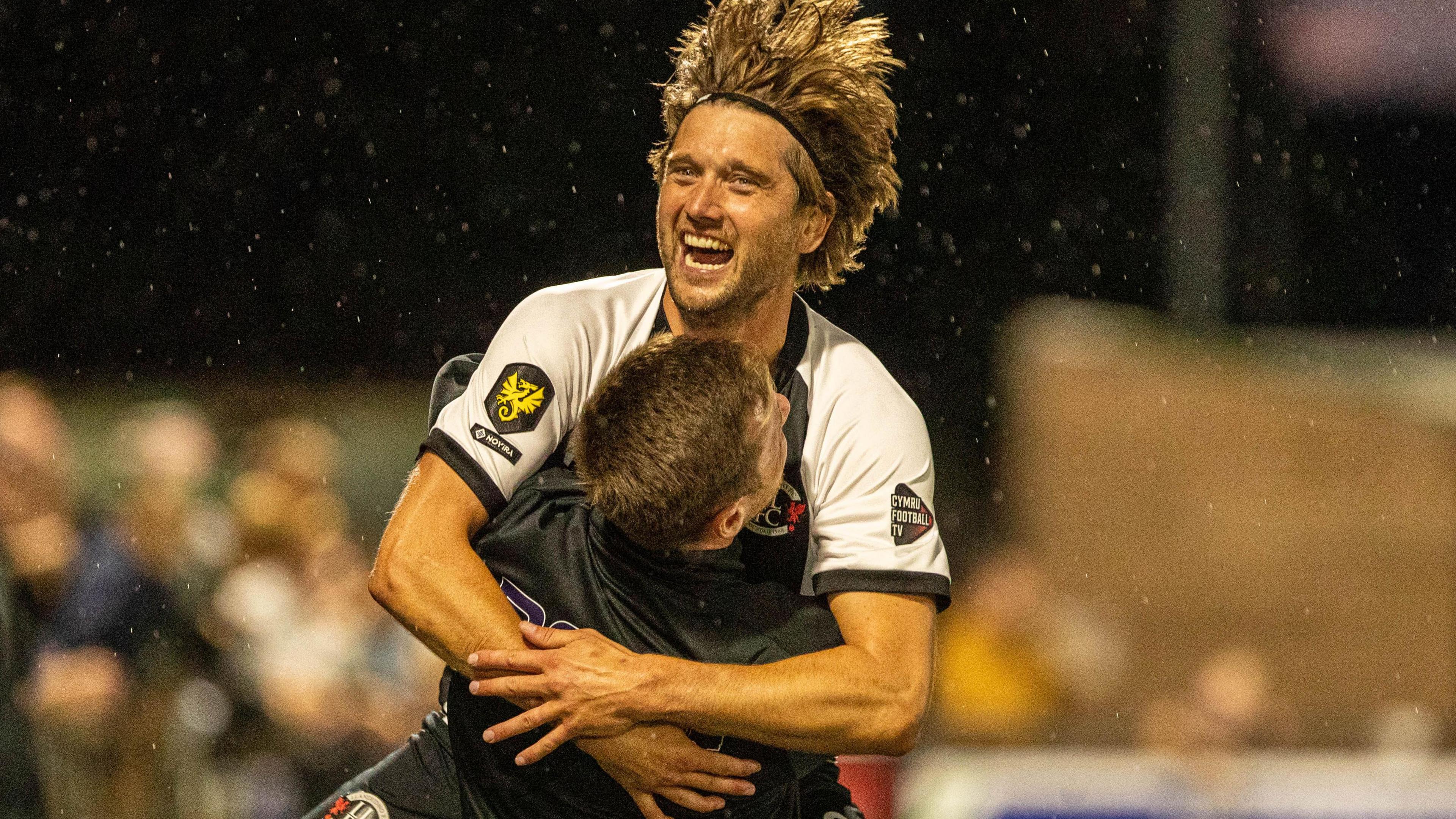 Llandudno's Mark Cadwallader celebrates his late winner against Flint with manager Jordan Hadaway.