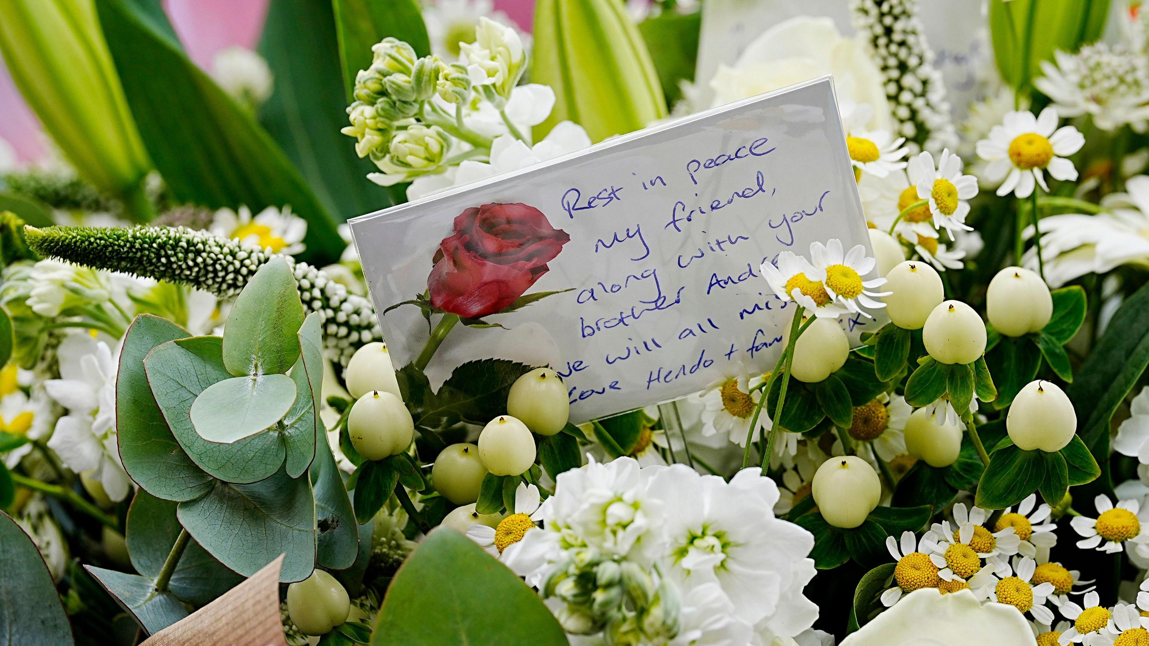 A handwritten card in the bunch of flowers brought by Jordan Henderson. It reads: Rest in peace, my friend, along with your brother Andre. We will all miss you. Love Hendo and family."