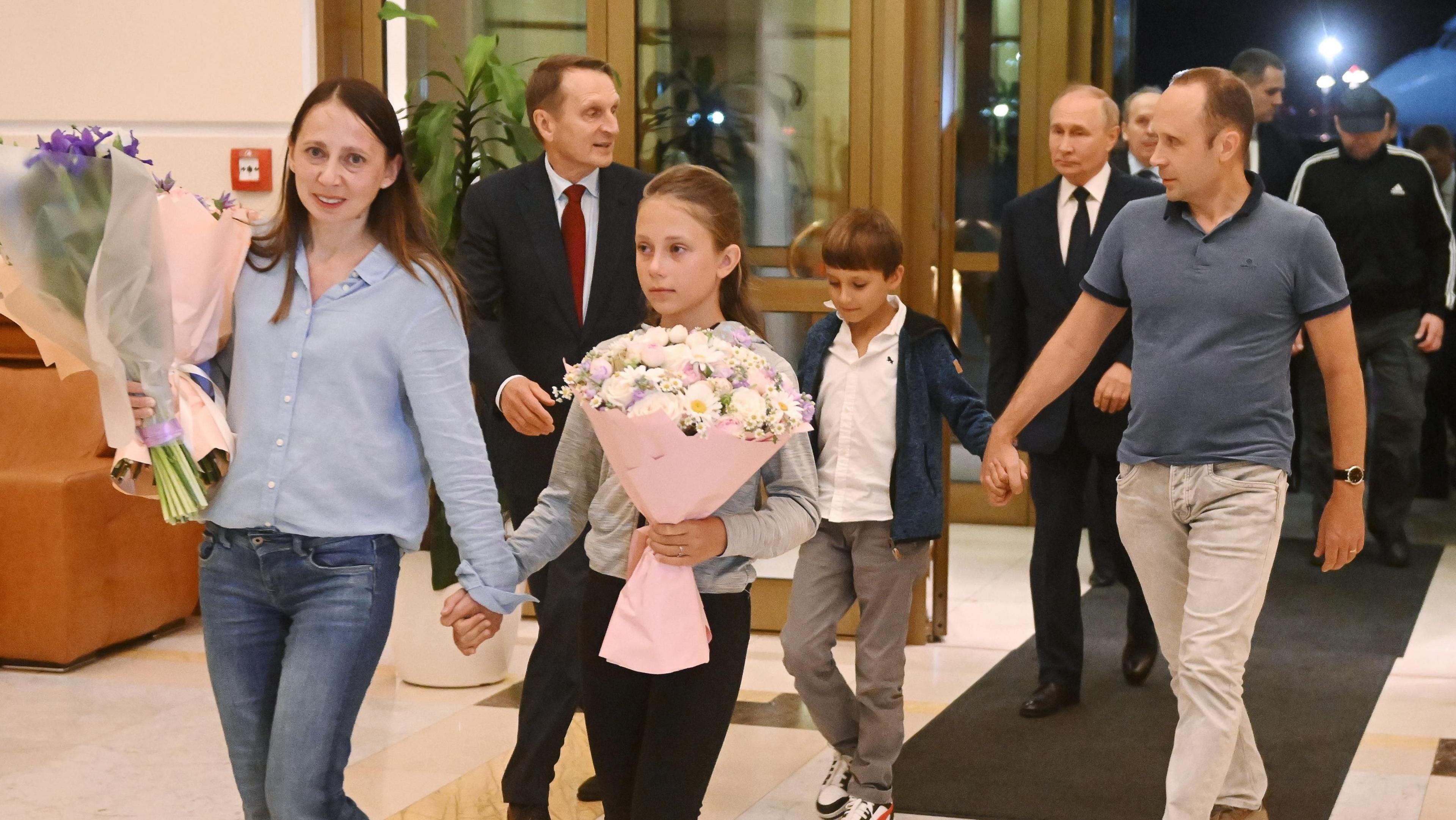 Anna Dultseva (L), Artyom Dultsev (R) with their two children, also Foreign Intelligence Service head Sergei Naryshkin (2nd L) and Vladimir Putin (2nd R)