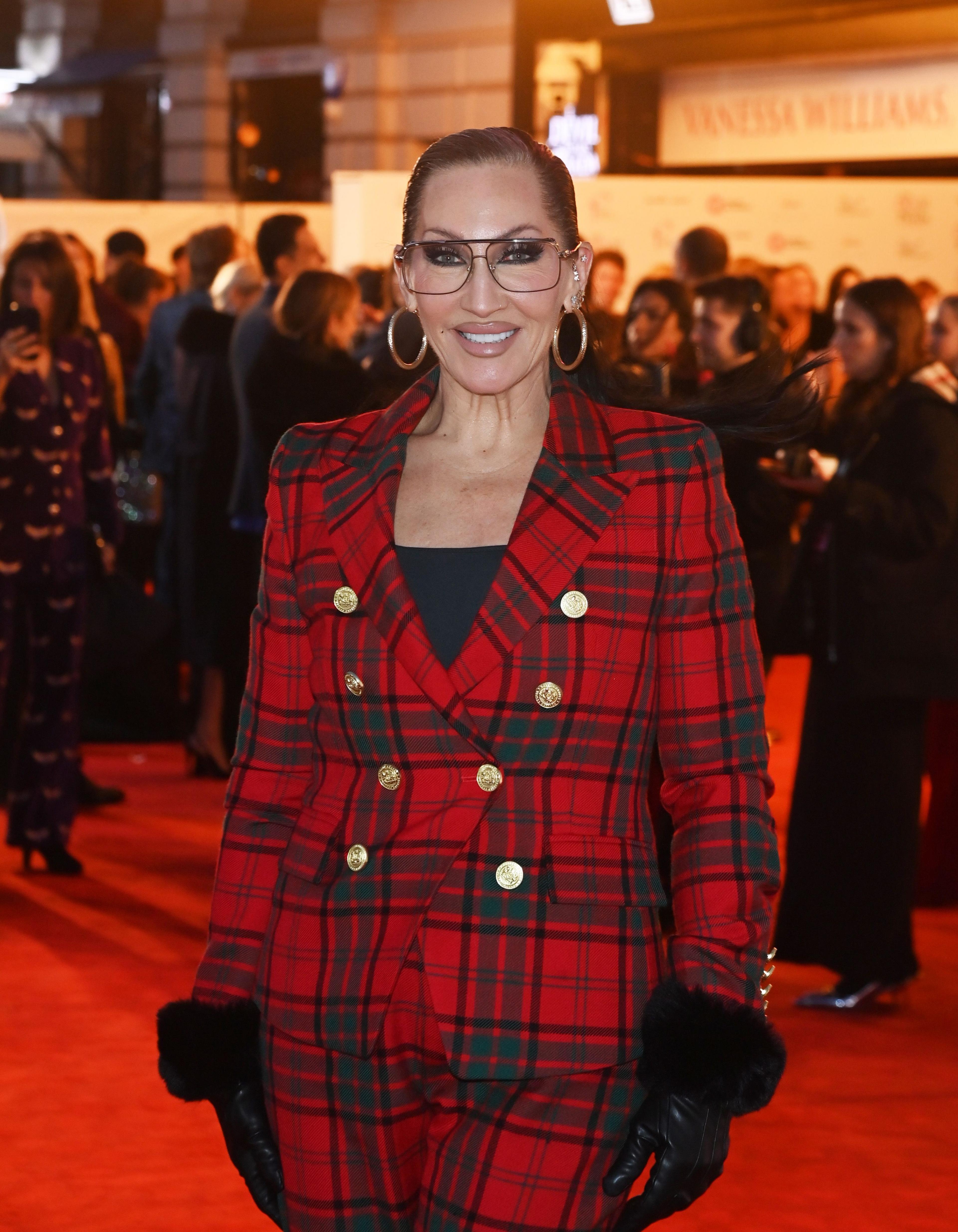 Michelle Visage in red suit on red carpet at The Dominion Theatre