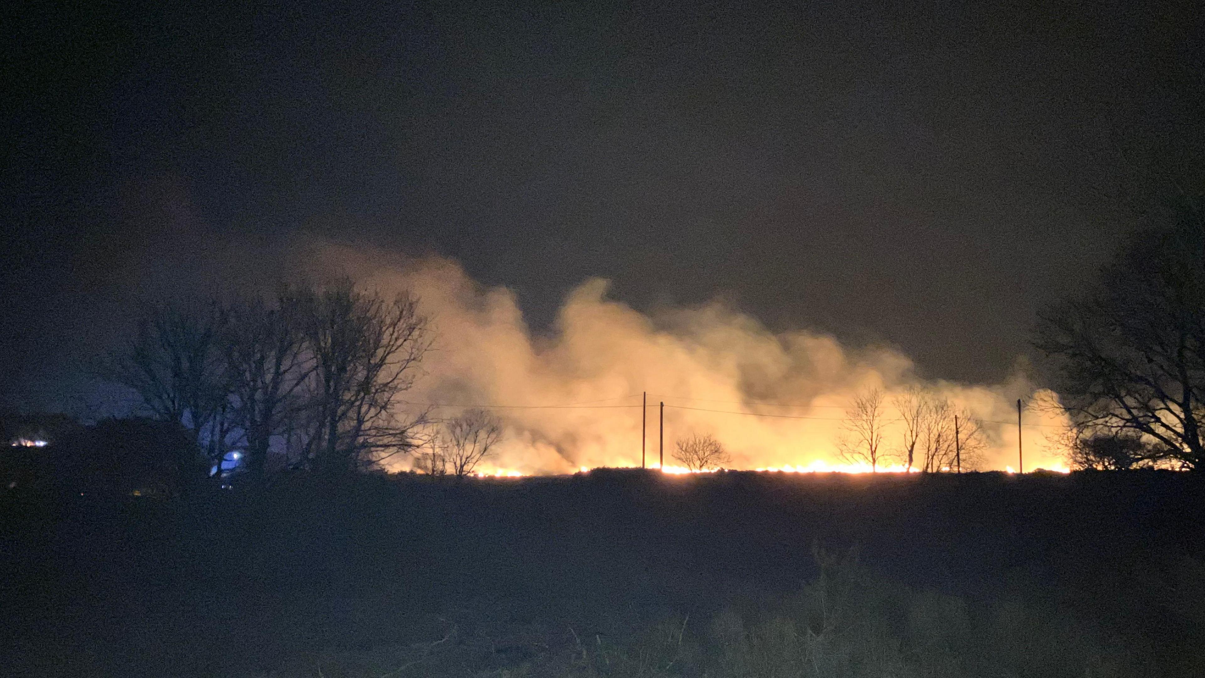 Fire photographed glowing in the darkness at Penrice, Horton, Swansea, Wales. 