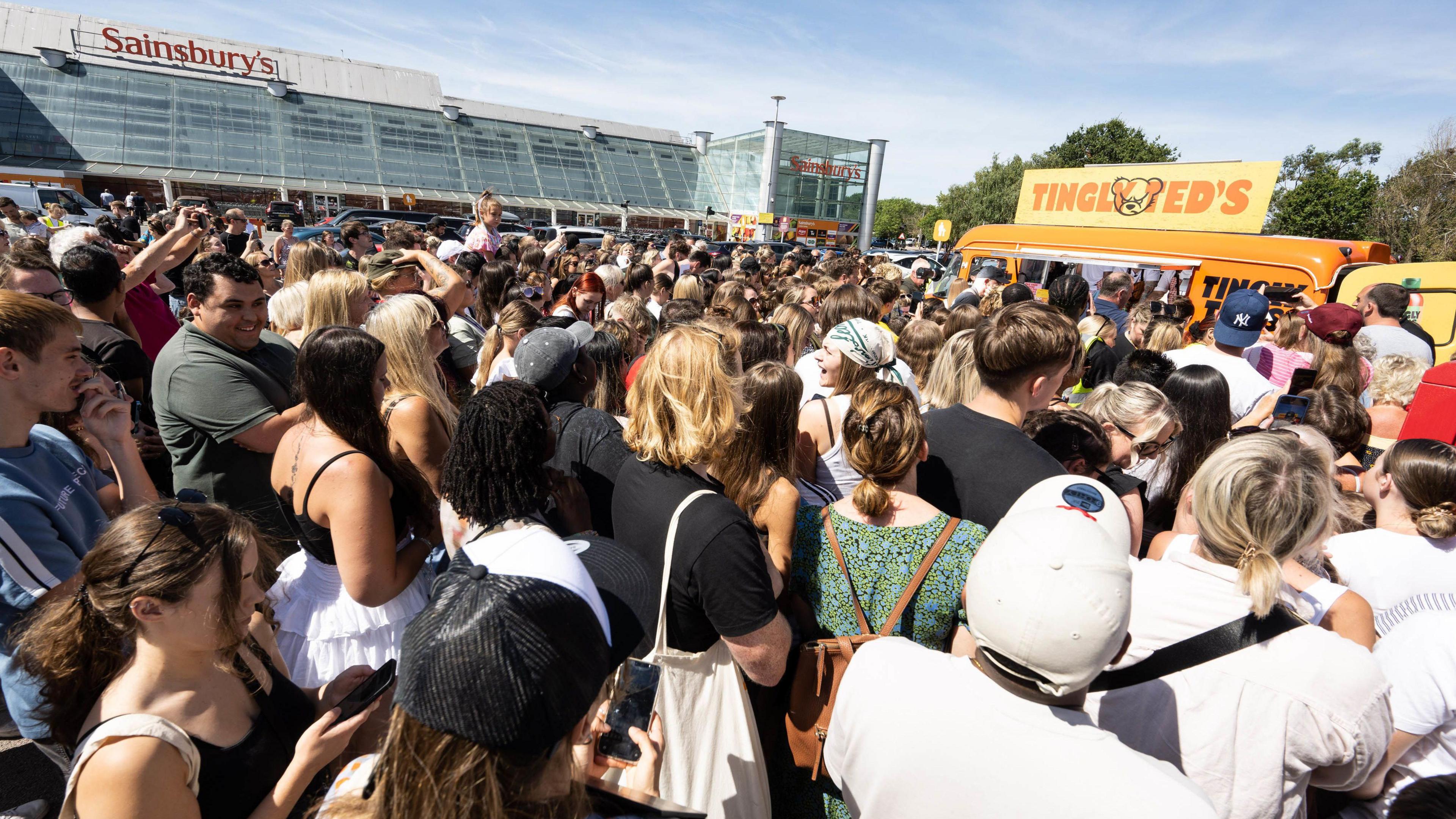 Crowd of fans waiting outside a Sainbury's in front of a van where singer Ed Sheeran was giving out autographs in hot sauce