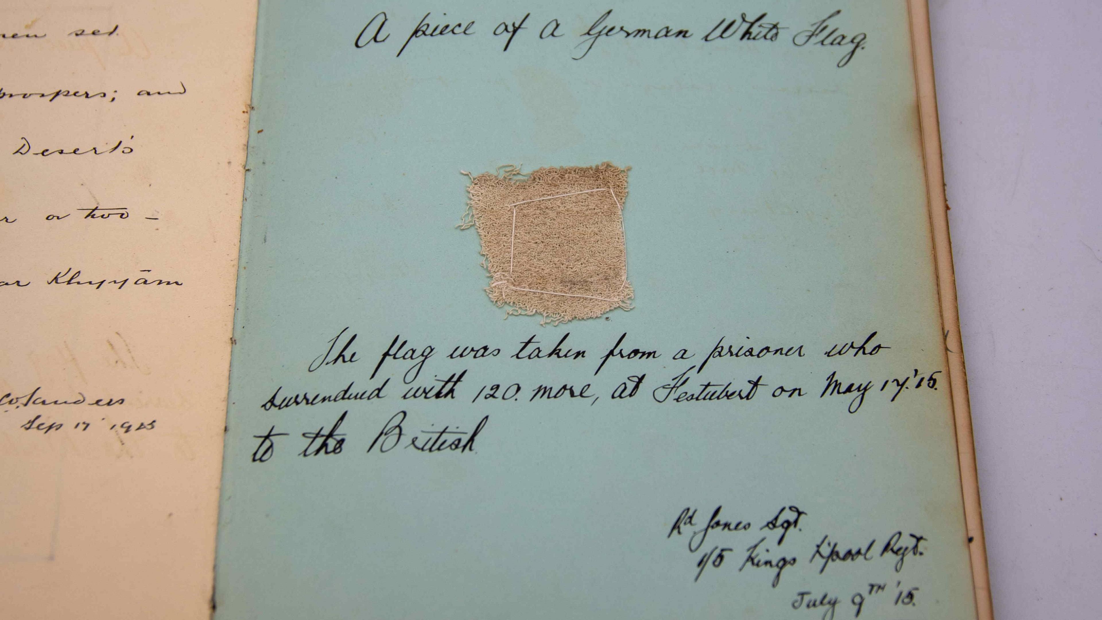 Page of the album showing a small piece of rough white material sewn to the page, with handwriting around it describing what it is and where it was gathered.