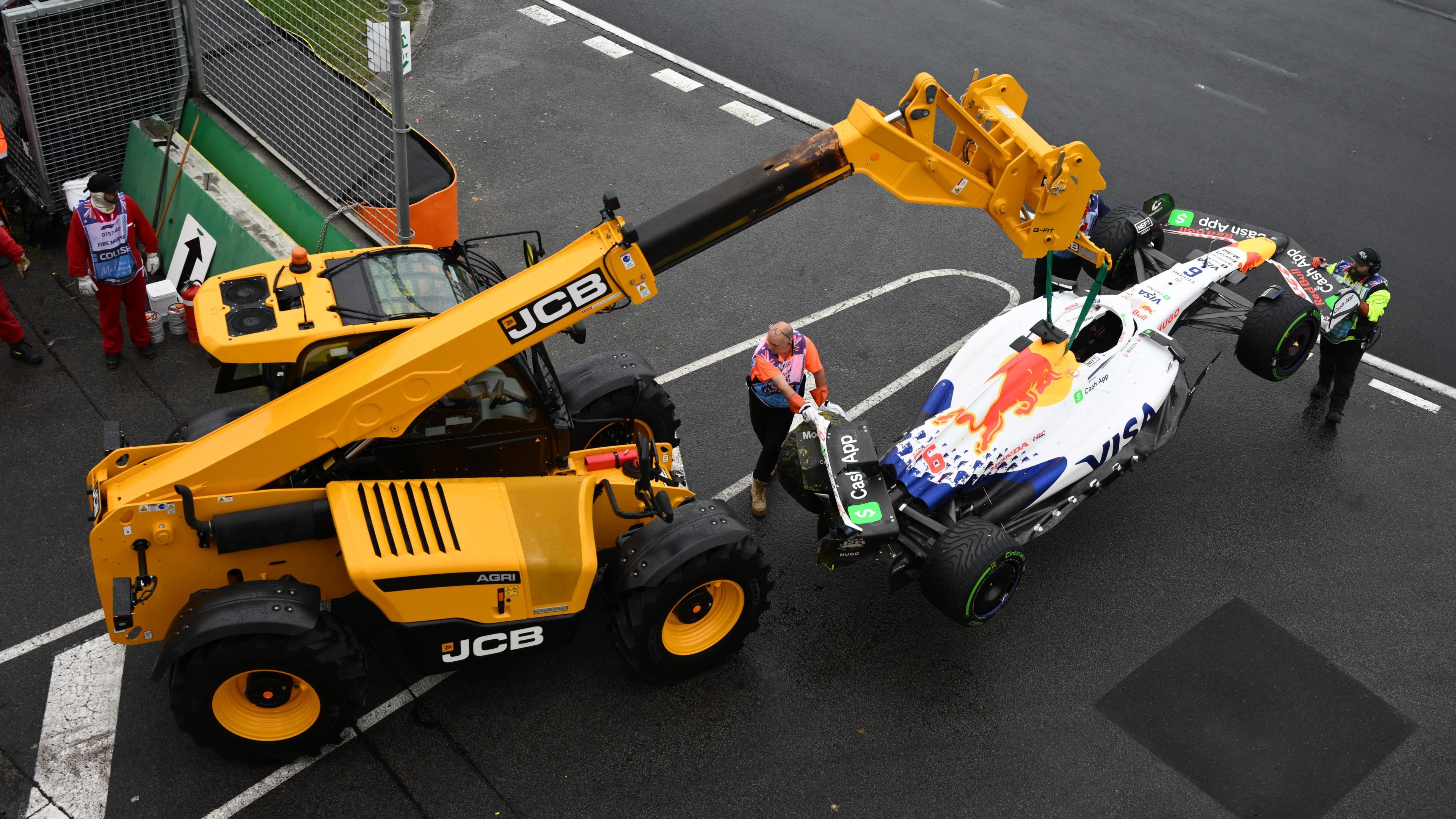 A crane lifting up Isack Hadjar's Racing Bulls car