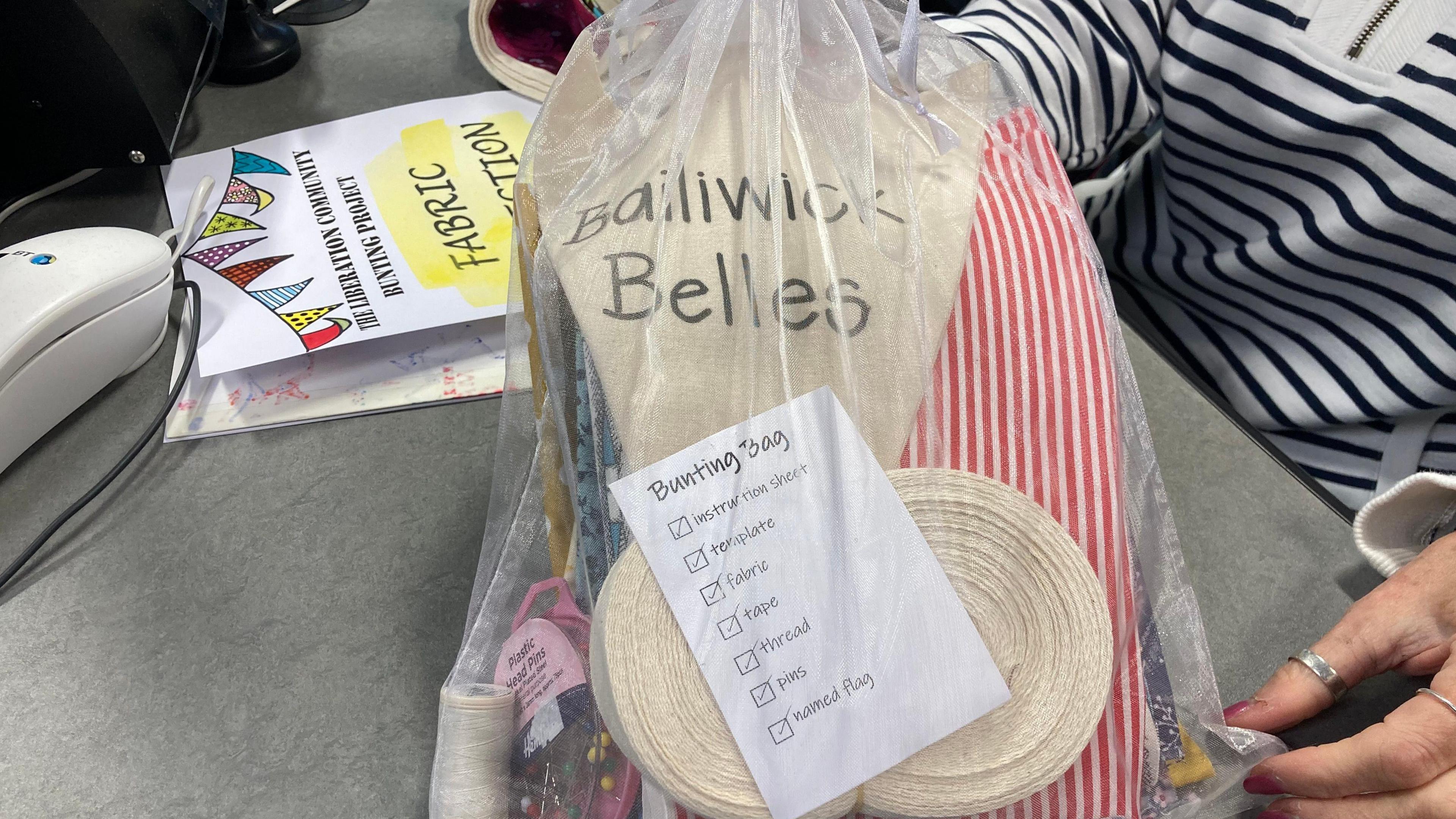 A bag of fabric, needles and ribbon, with a label saying "Bunting Bag"