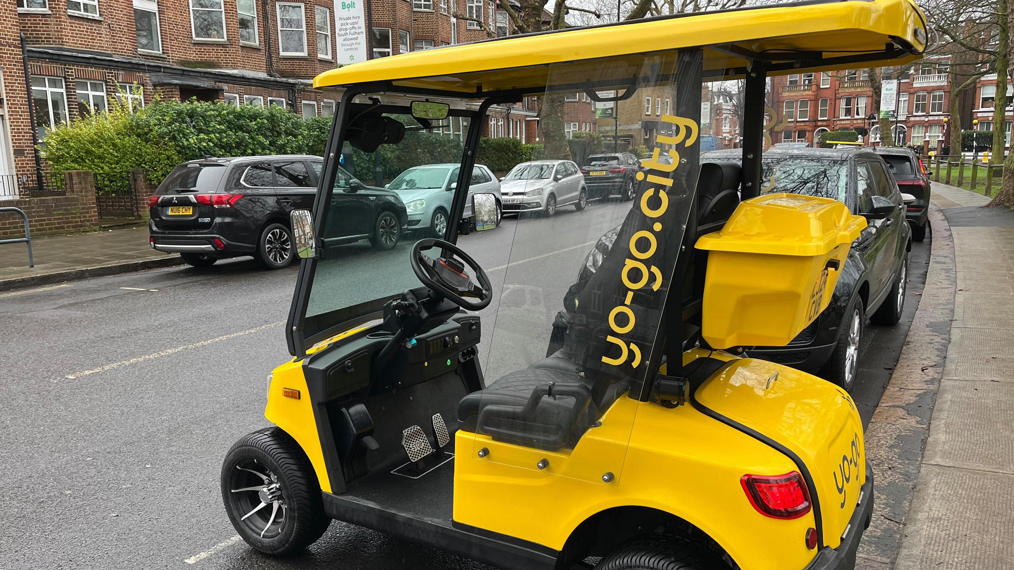 A yellow buggy is parked in a road