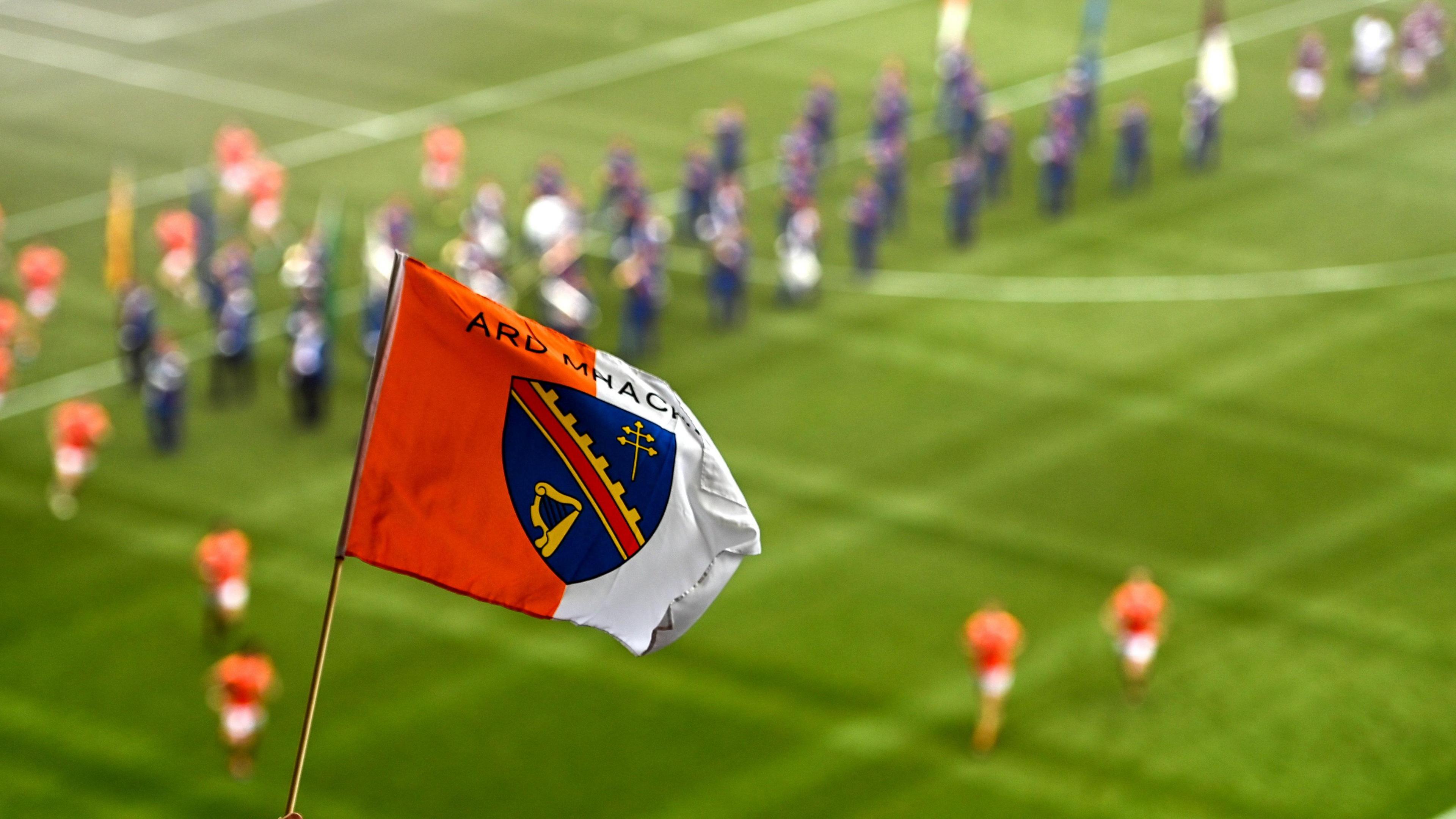 A County Armagh flag with a blurry GAA pitch in the background