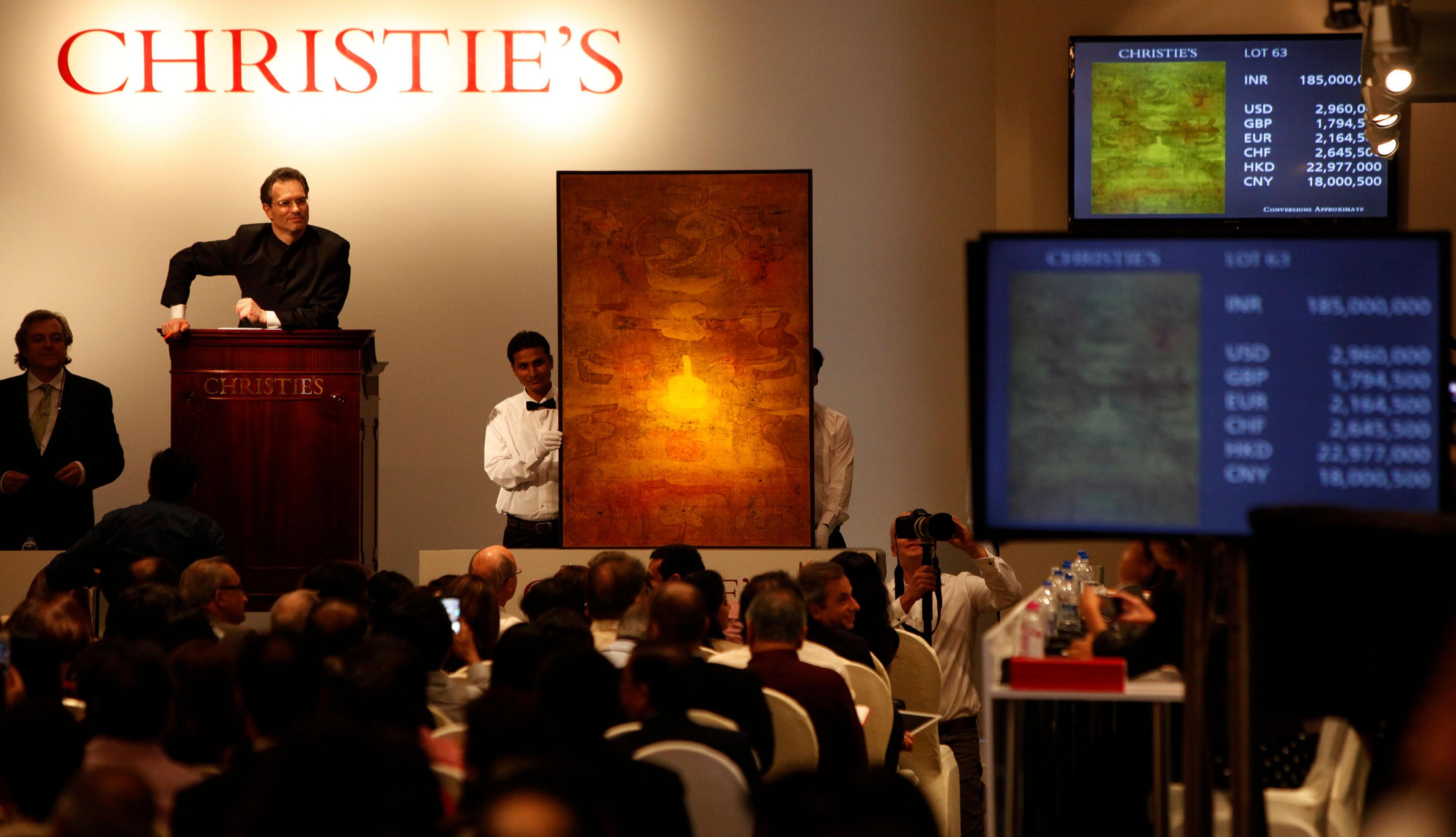 Auctioneer Hugo Weihe interacts with bidder on Vasudeo S Gaitonde's (1924-2001) untitled oil painting painted in 1979, at India's first South Asia Art organized by Christie's at Taj Mahal hotel, on December 19, 2013 in Mumbai, India. 
