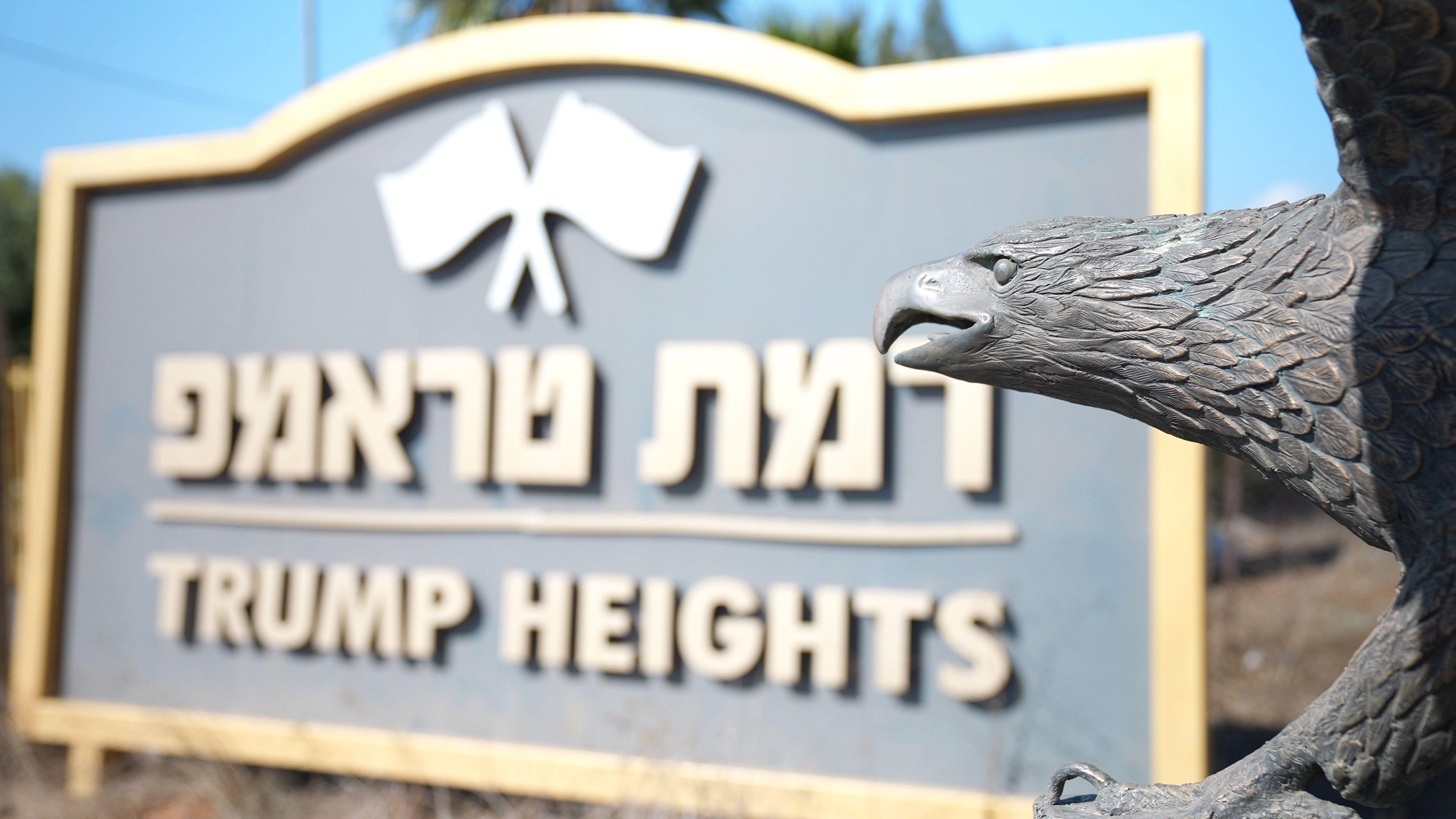 The sign for Trump Heights with a bronze eagle sculpture in front of it