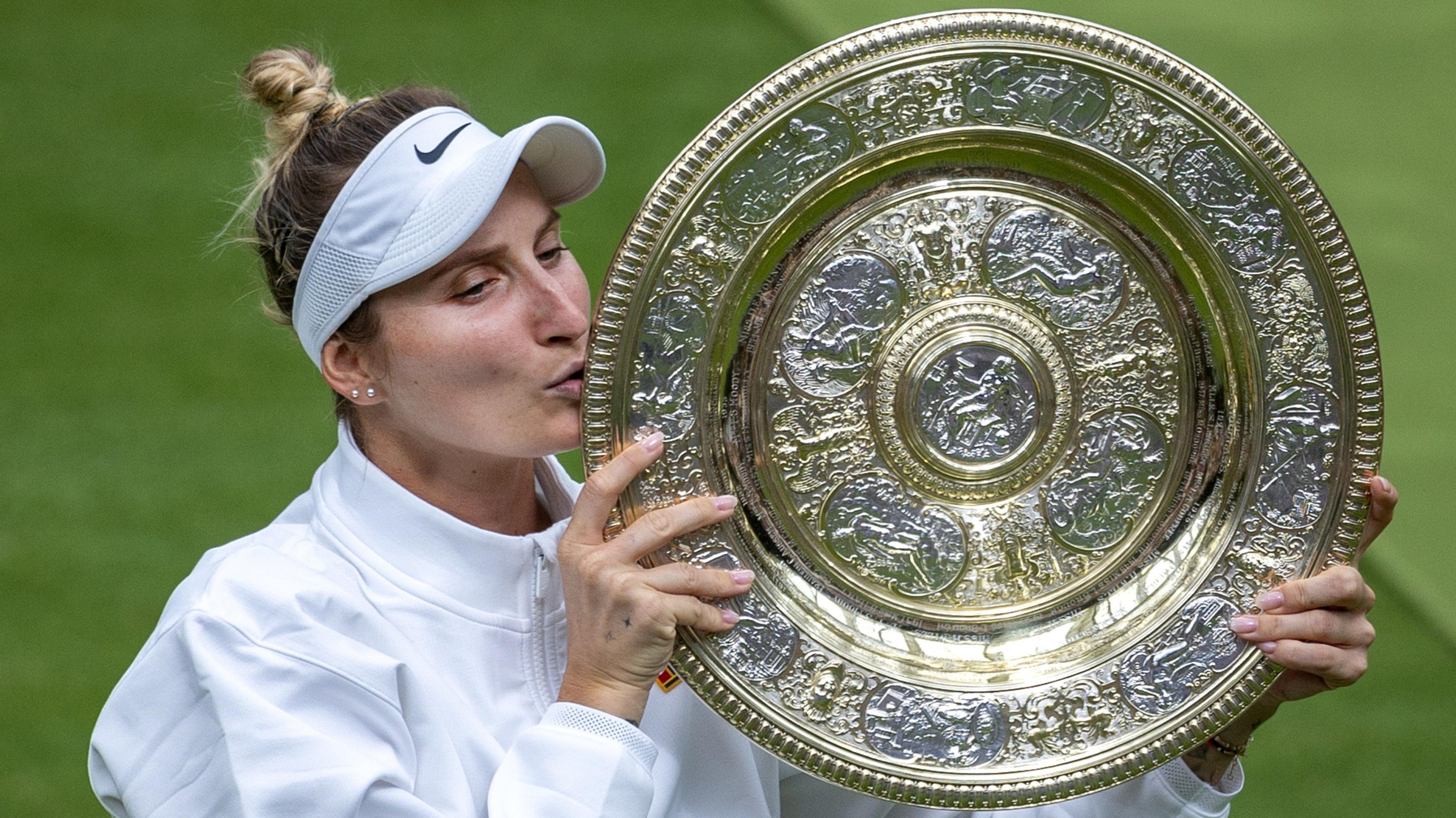 Marketa Vondrousova kisses the Venus Rosewater Dish at Wimbledon in 2023 