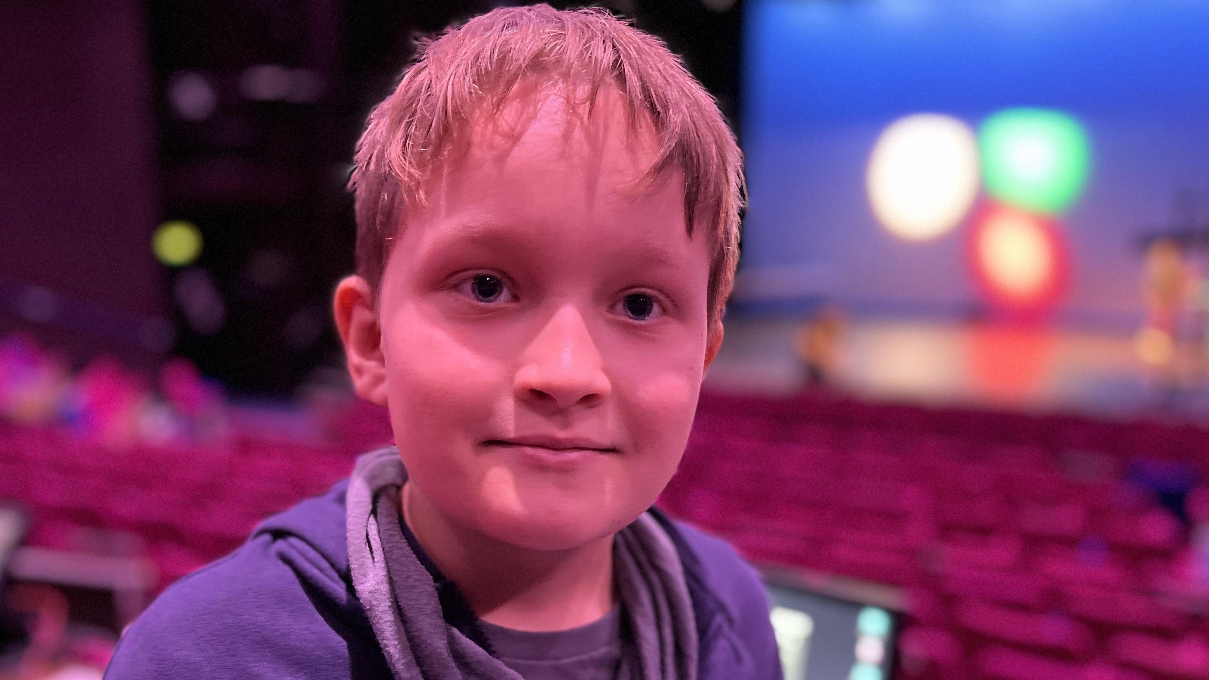 10-year-old, Pawel, stood by the lighting and sound controls with the theatre seats and stage behind him