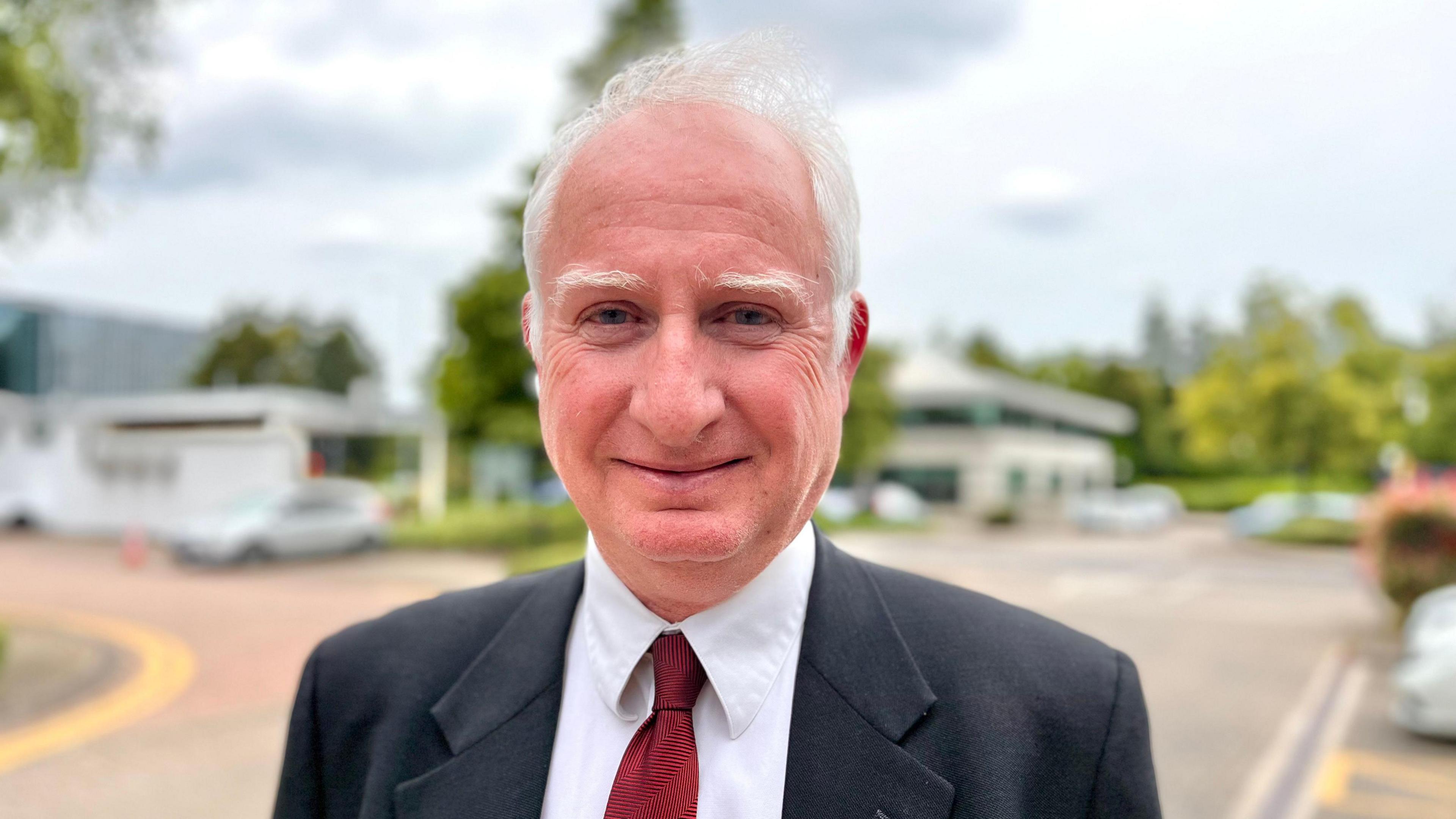 Profile picture of Daniel Zeichner. He is wearing a dark suit jacket, red tie and white shirt. 