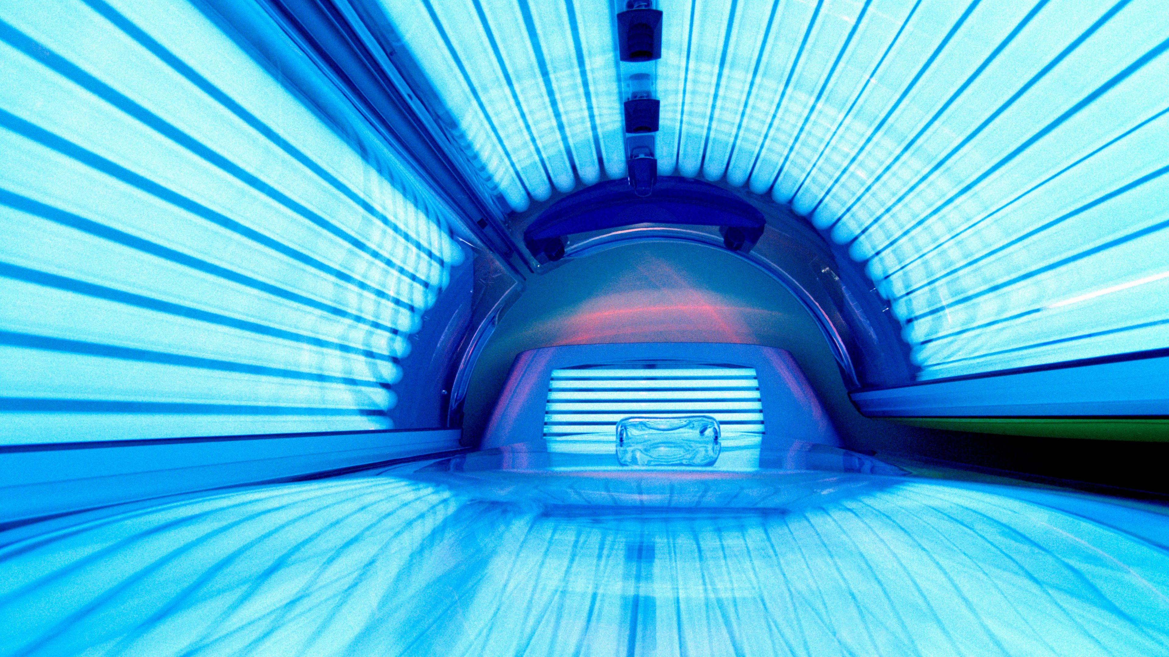 The inside of a sunbed. Blue lights are shining from tanning lamps.