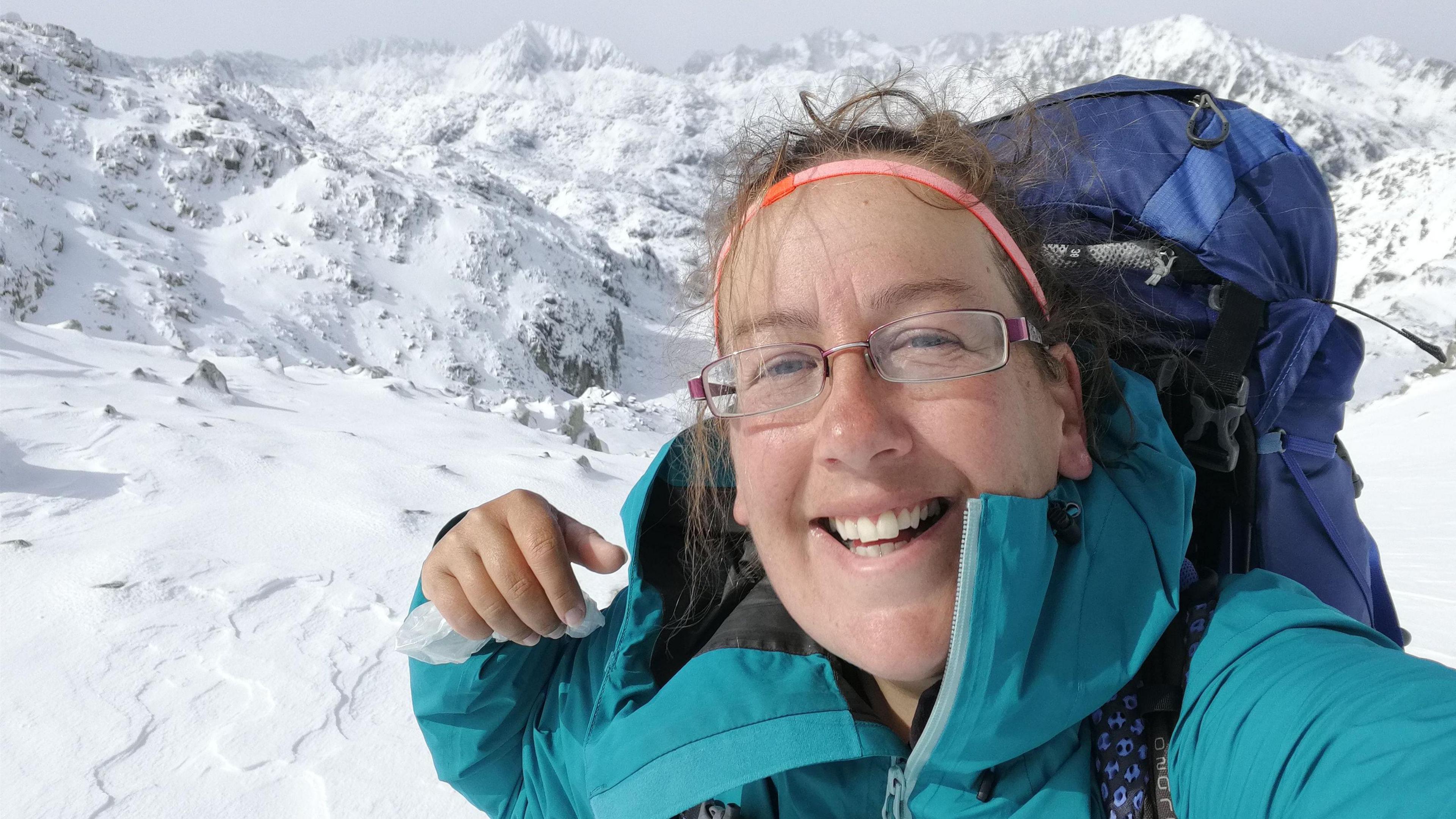 Ursula Martin wearing glasses and blue coat whilst walking through snowstorm in Spain