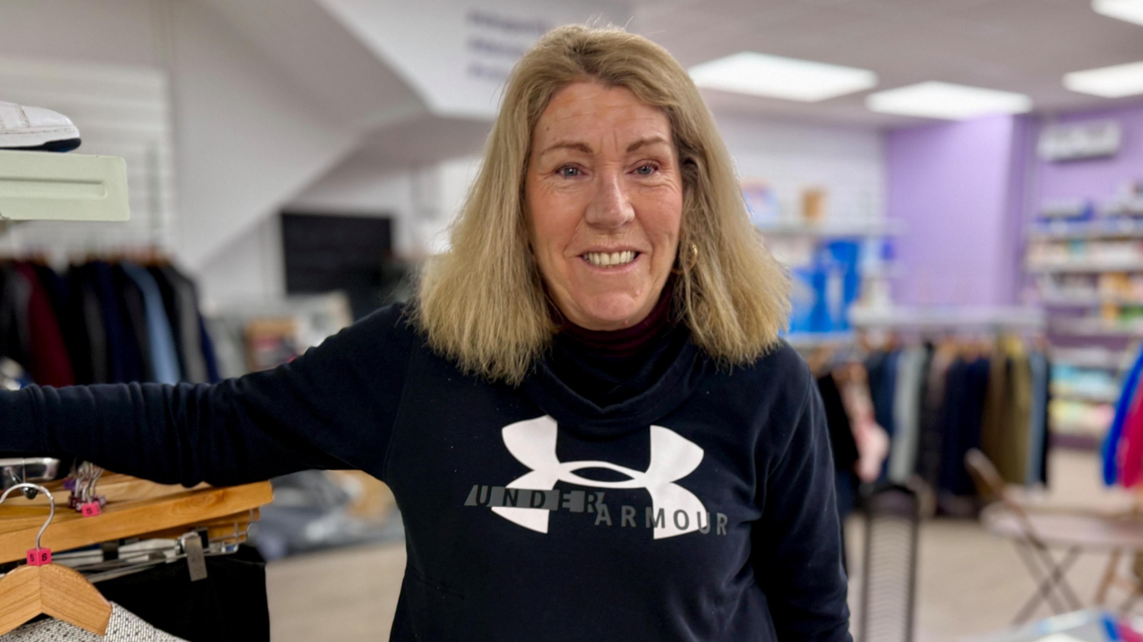 Michelle Smith is stood in her shop with a black jumper and blonde hair