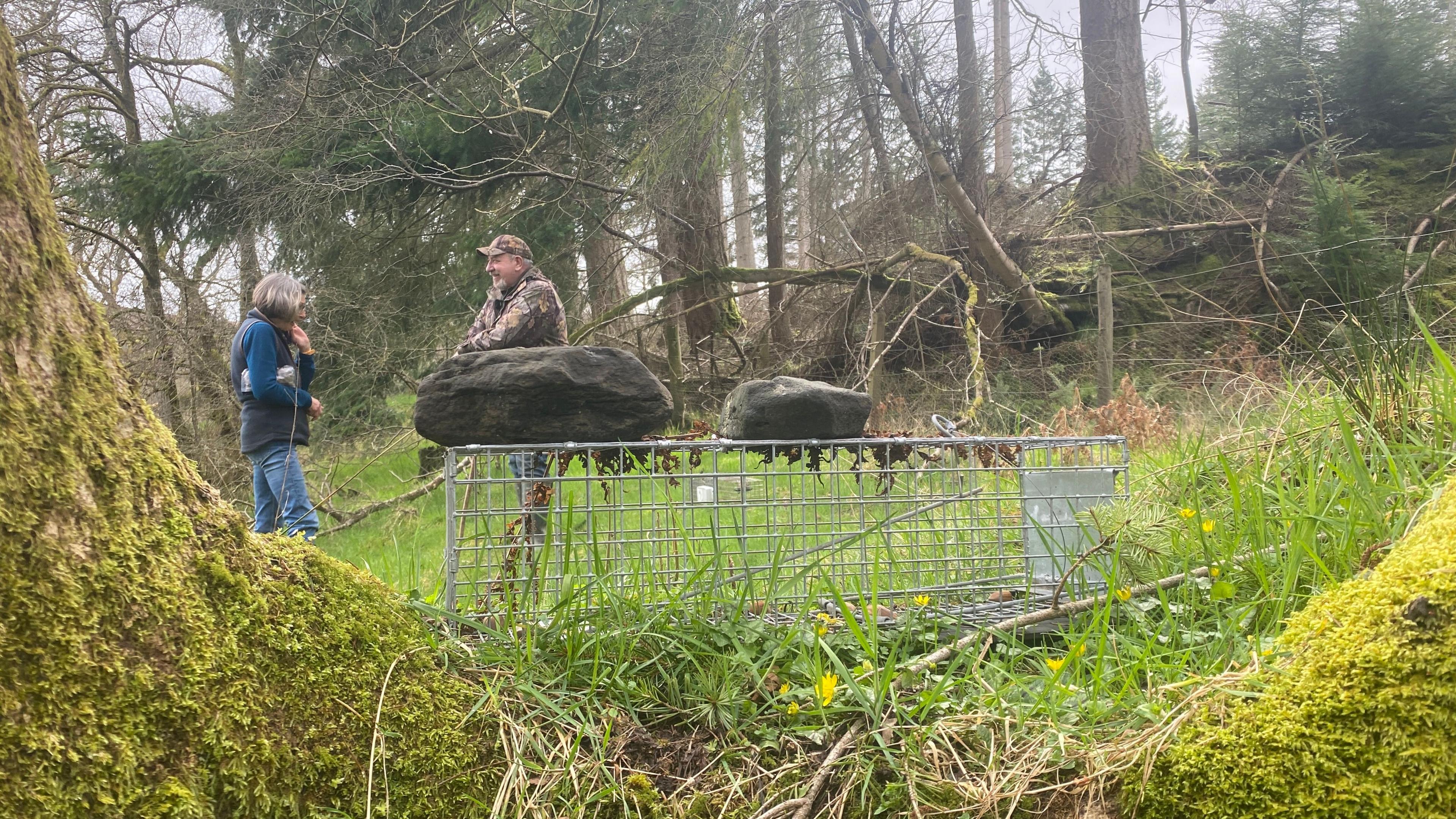 A picture of a cage with two people talking behind