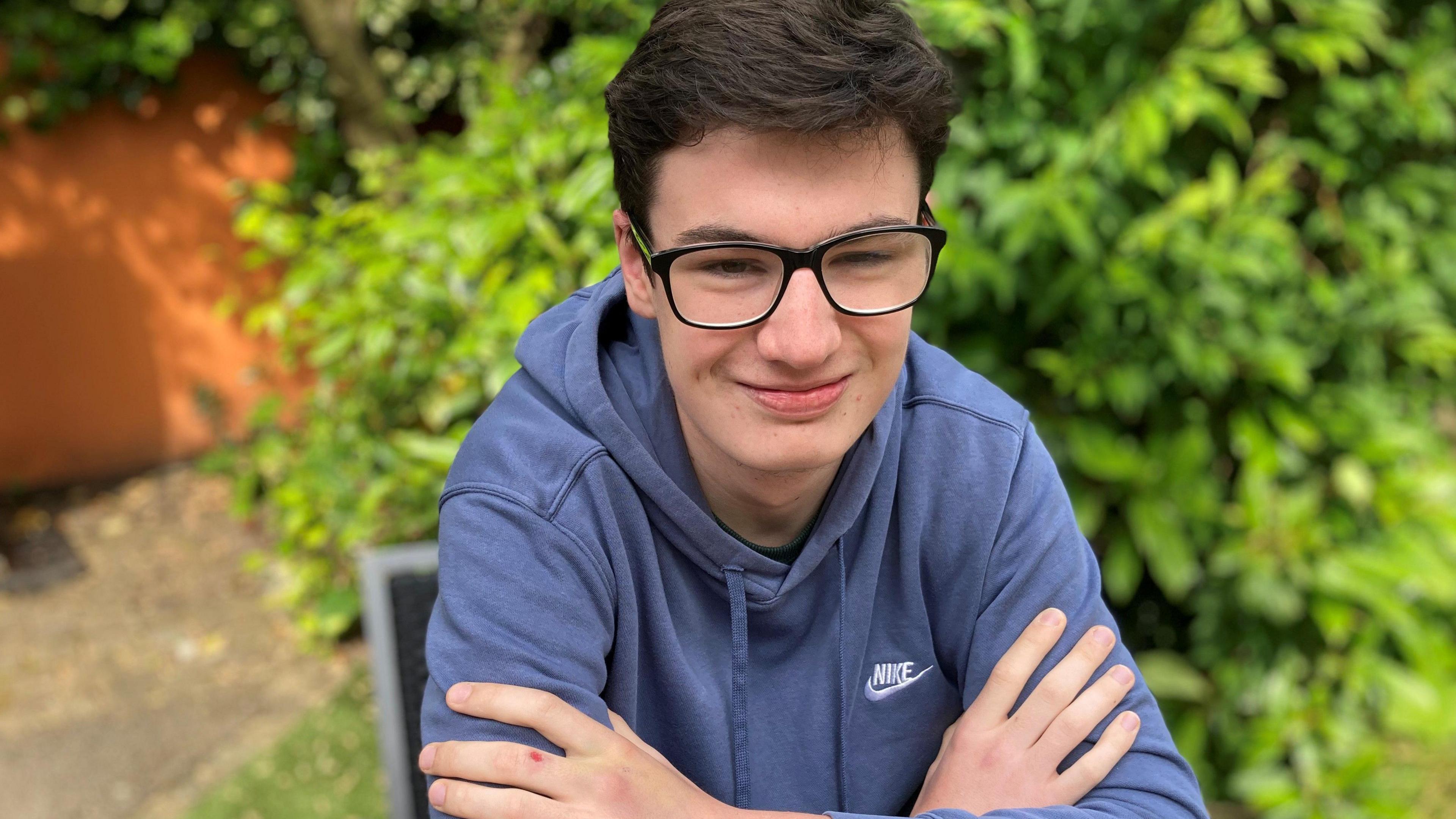 James, wearing glasses and a blue top