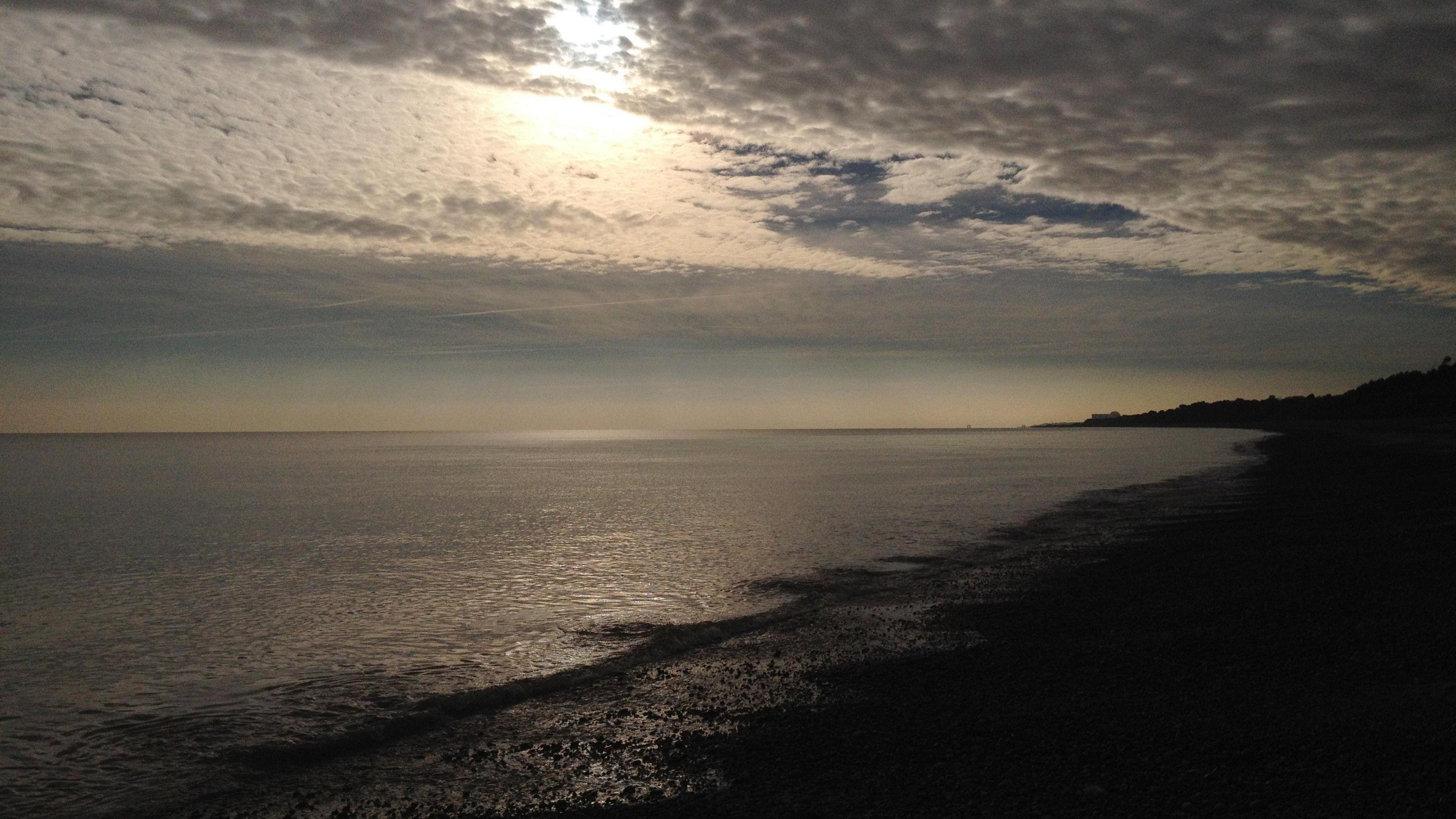 A wide shot of a coastline under a moonlit skyline.