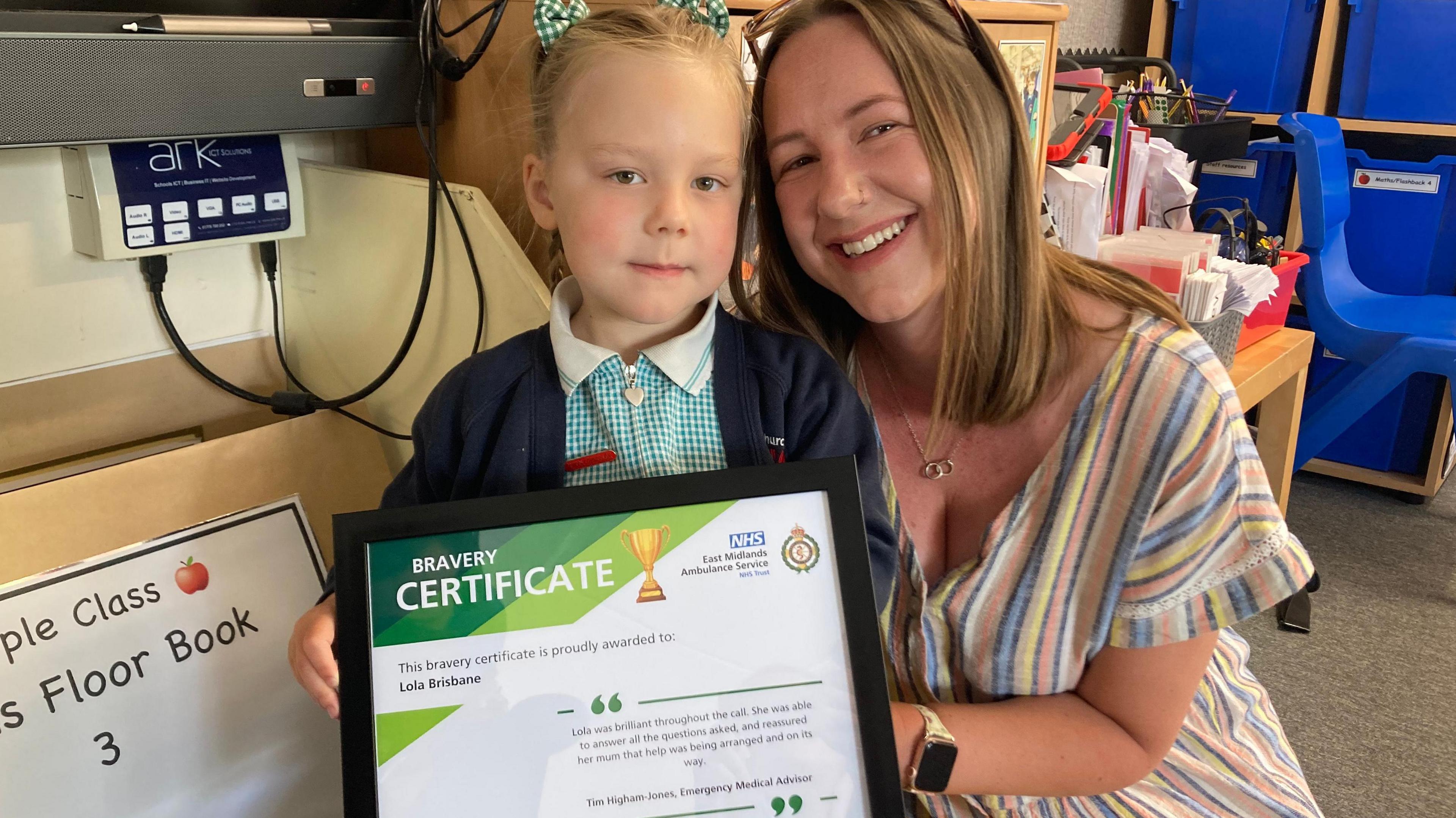 Lola pictured with her bravery award alongside her smiling mum, Kirstie