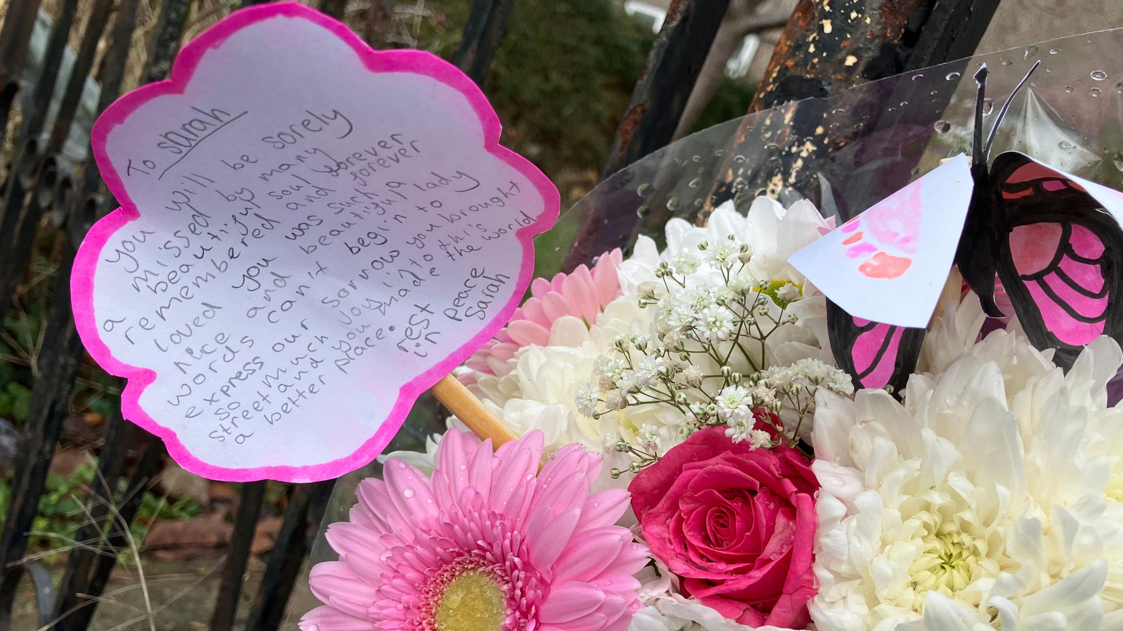 A close-up image of a colourful bouquet of flowers with a message sticking out.