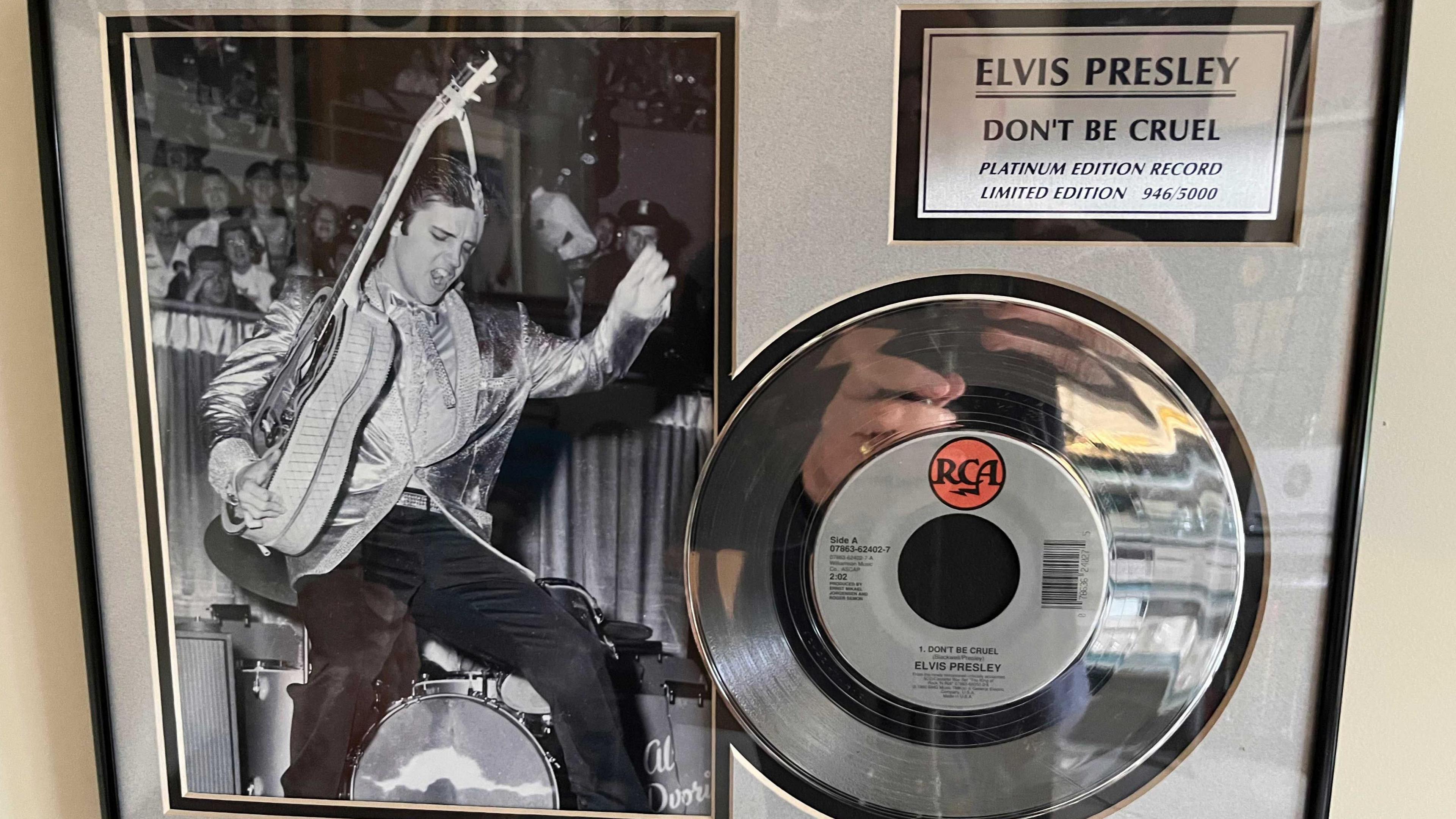 A photo of Elvis holding his guitar and dancing is next to a silver 7" record. A label says 'Elvis Presley, Don't be Cruel platinum edition record. Limited edition 946/5000'