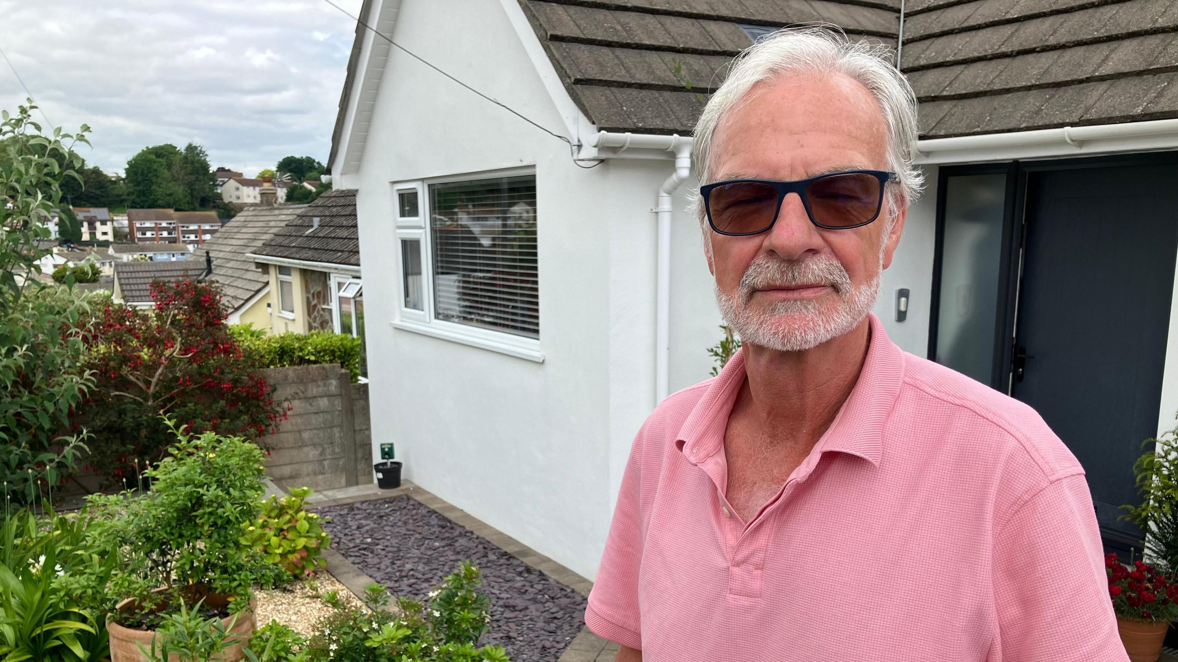 Man standing in the front garden of a house 