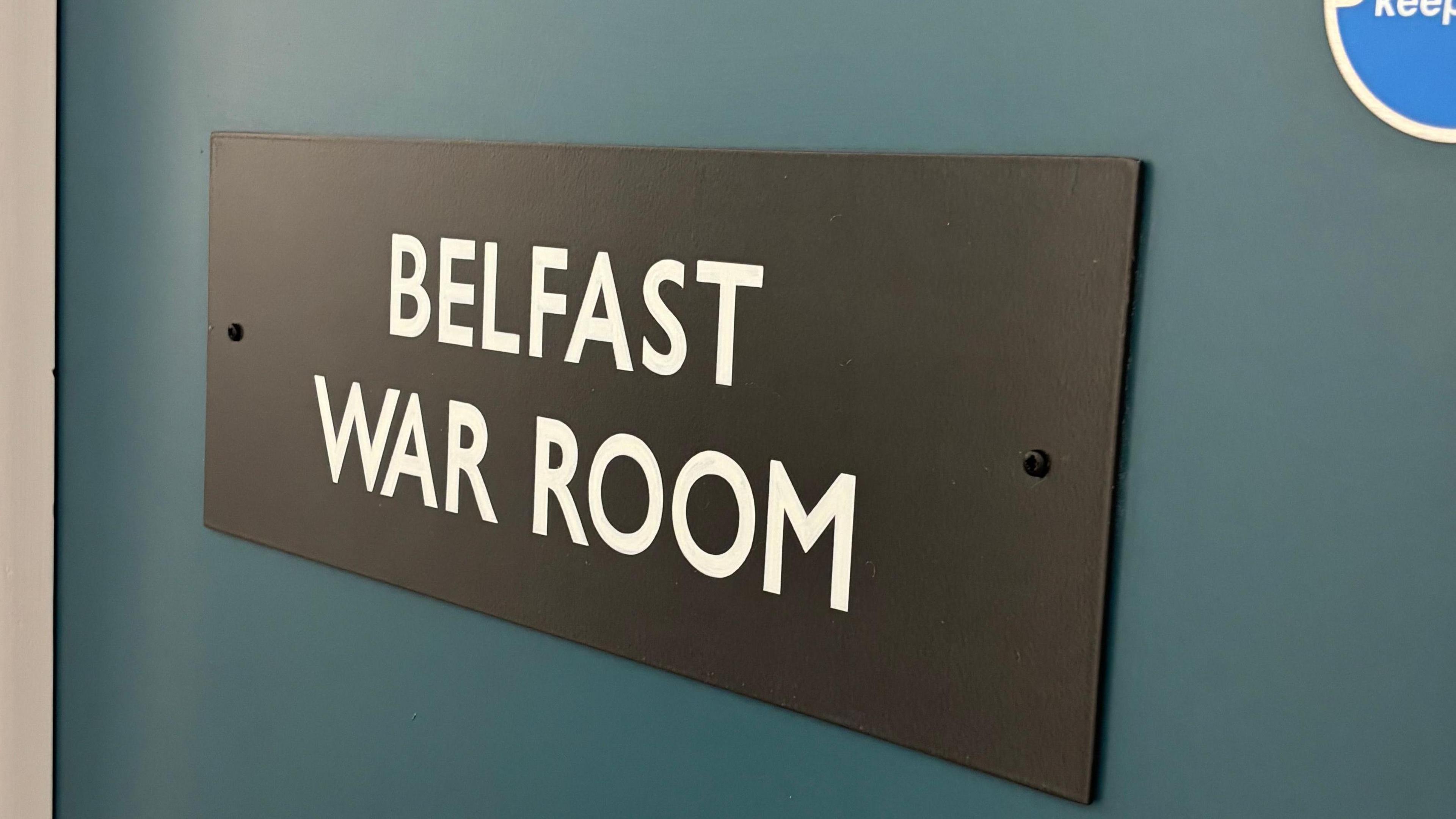 A sign on a blue door says Belfast War Room
