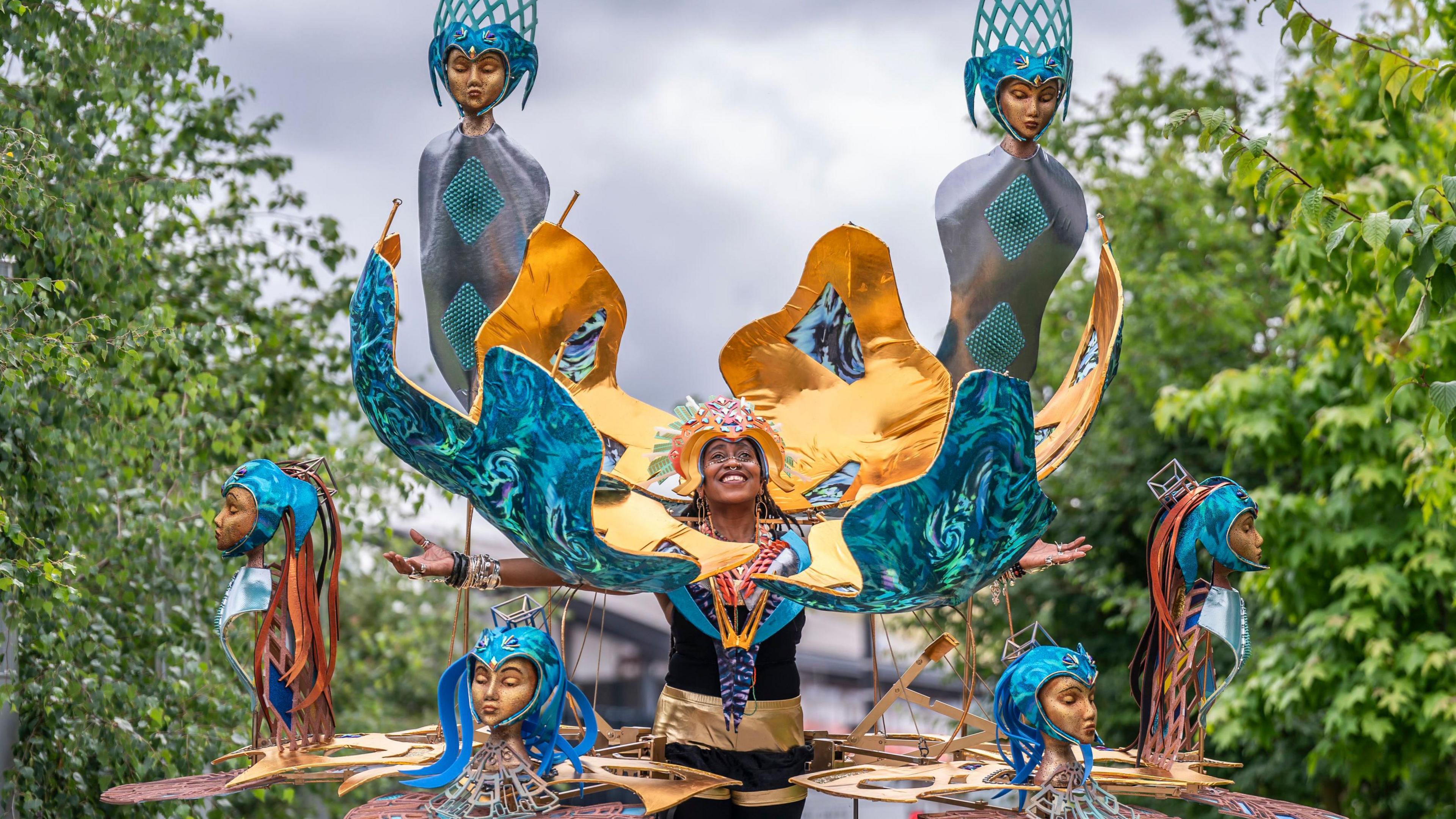 The striking garment is 3m in diameter and more than 3m high and features six gold-coloured aluminium arms and six heads, each with flowing hair.