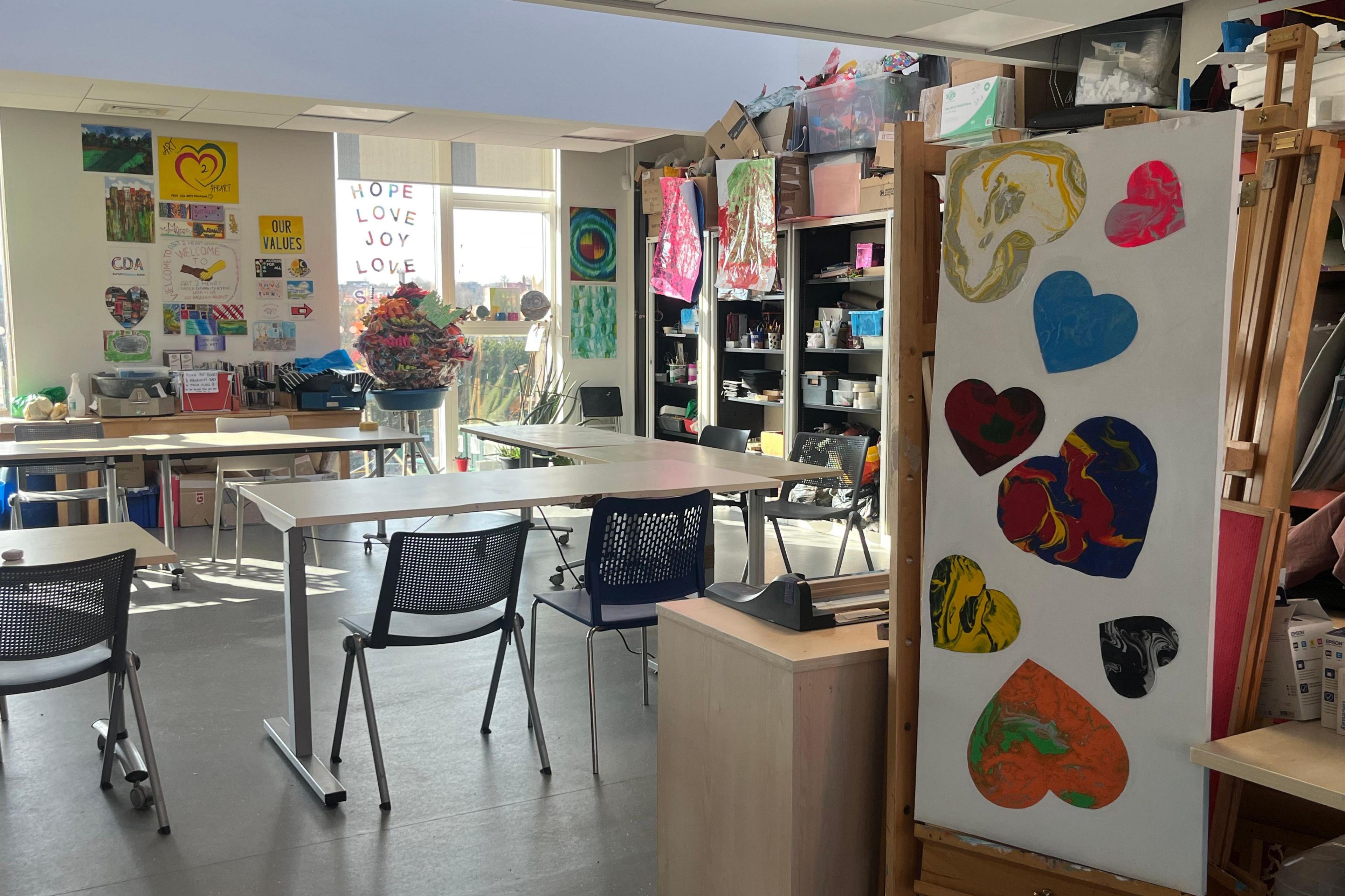 Greenwood Centre classrooms shows homemade hearts on display in a classroom with desks and chairs and a bright window letting light it