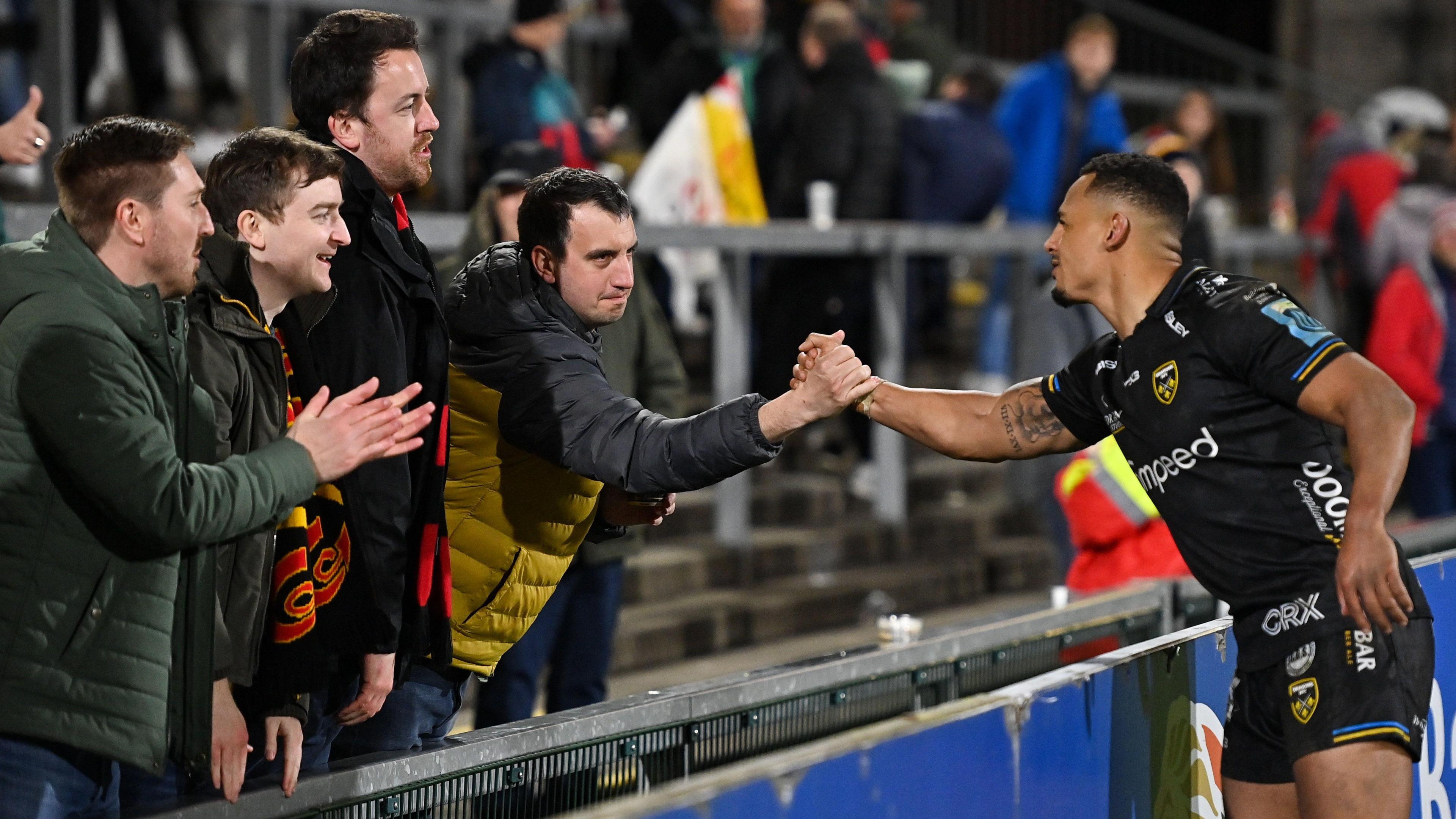 Ashton Hewitt shaking hands with supporter